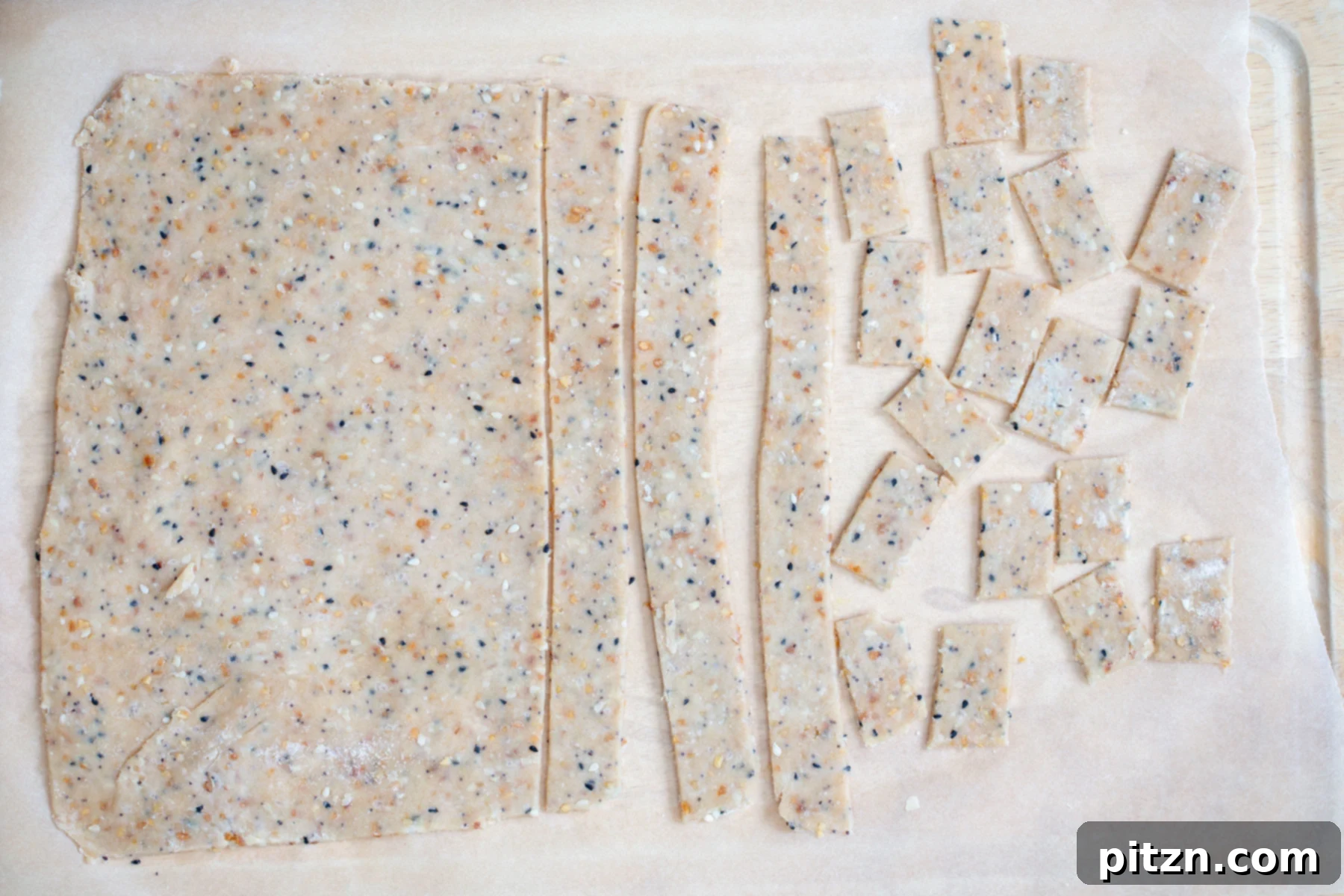 vegan bagel cracker dough being rolled out an cut into small squares