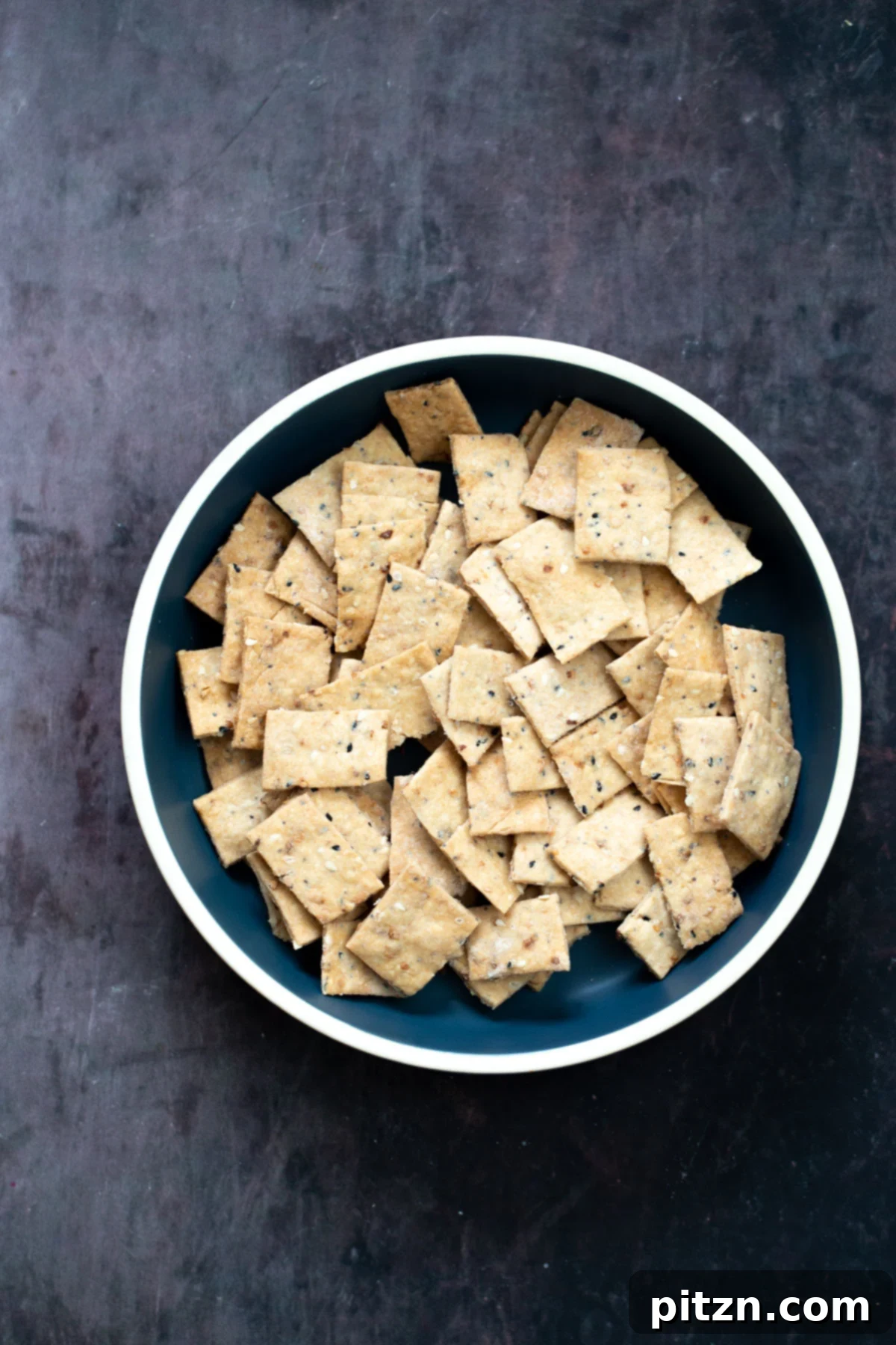 overhead shot of a bowl with vegan Everything Bagel Crackers 