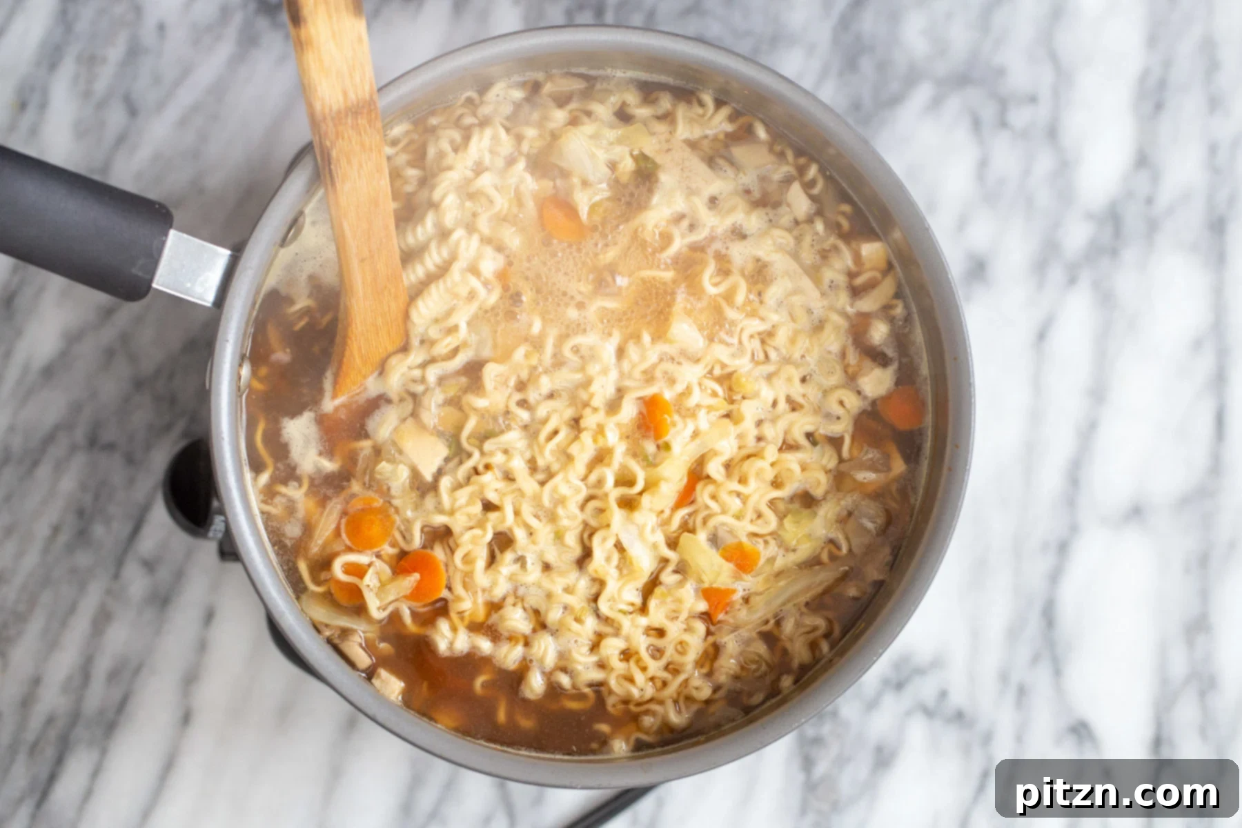 Vegan Hot and Sour Ramen Bowl 11 Ramen noodles cooking in a rich hot and sour broth, absorbing the flavors and thickening the soup to perfection.