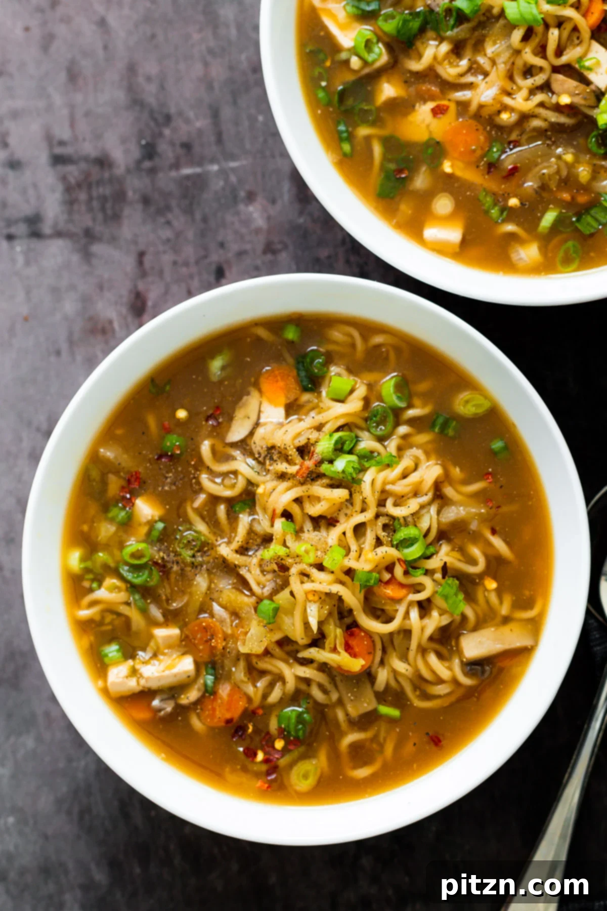 Vegan Hot and Sour Ramen Bowl 5 Close-up of two elegantly presented bowls of Vegan Hot and Sour Ramen Soup, showcasing the texture of the noodles and the rich color of the broth.
