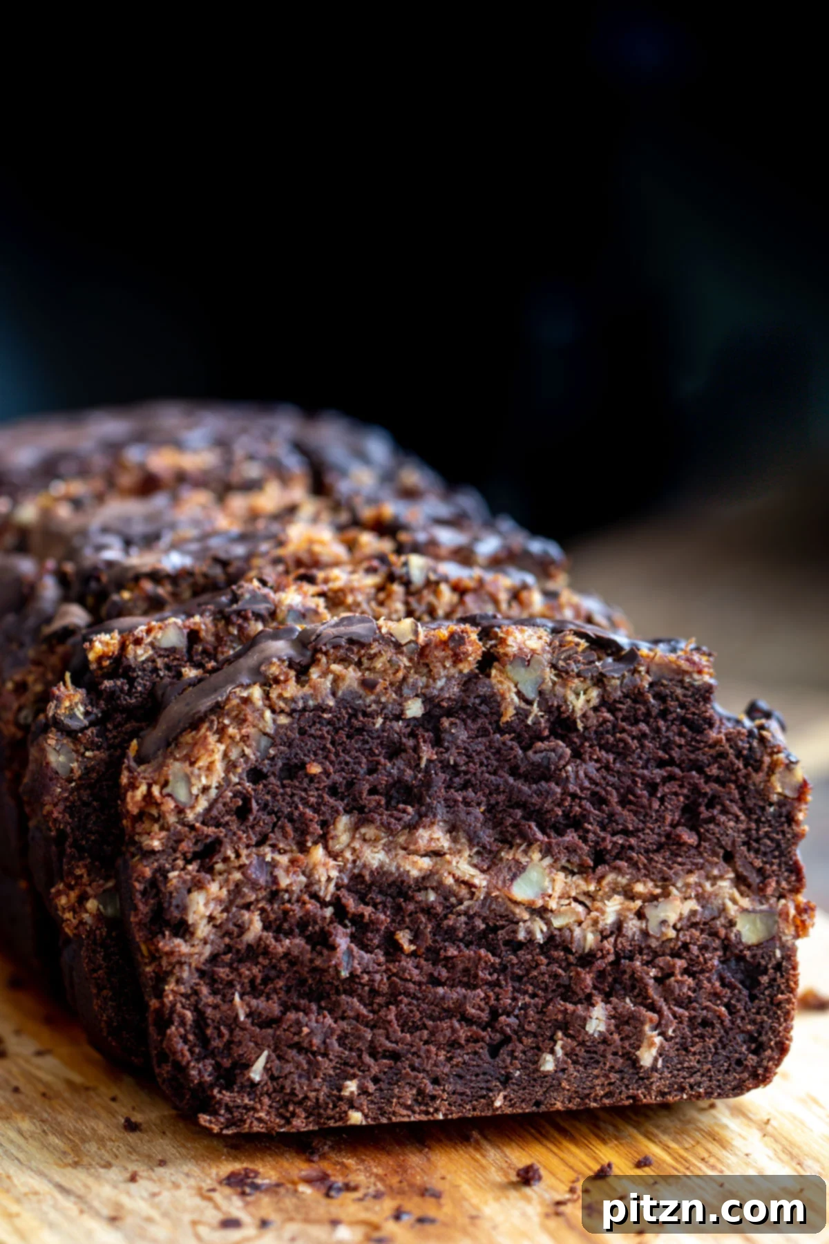 Delicious Vegan German Chocolate Loaf Cake with Coconut Caramel Swirl A close-up view of the vegan German Chocolate Loaf Cake, showcasing the beautifully integrated coconut caramel swirl running through the moist chocolate cake. The texture is inviting and rich.