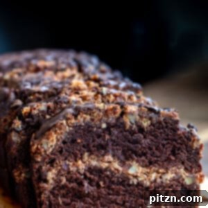 A slice of Vegan German chocolate loaf cake with the coconut pecan caramel swirl visible.