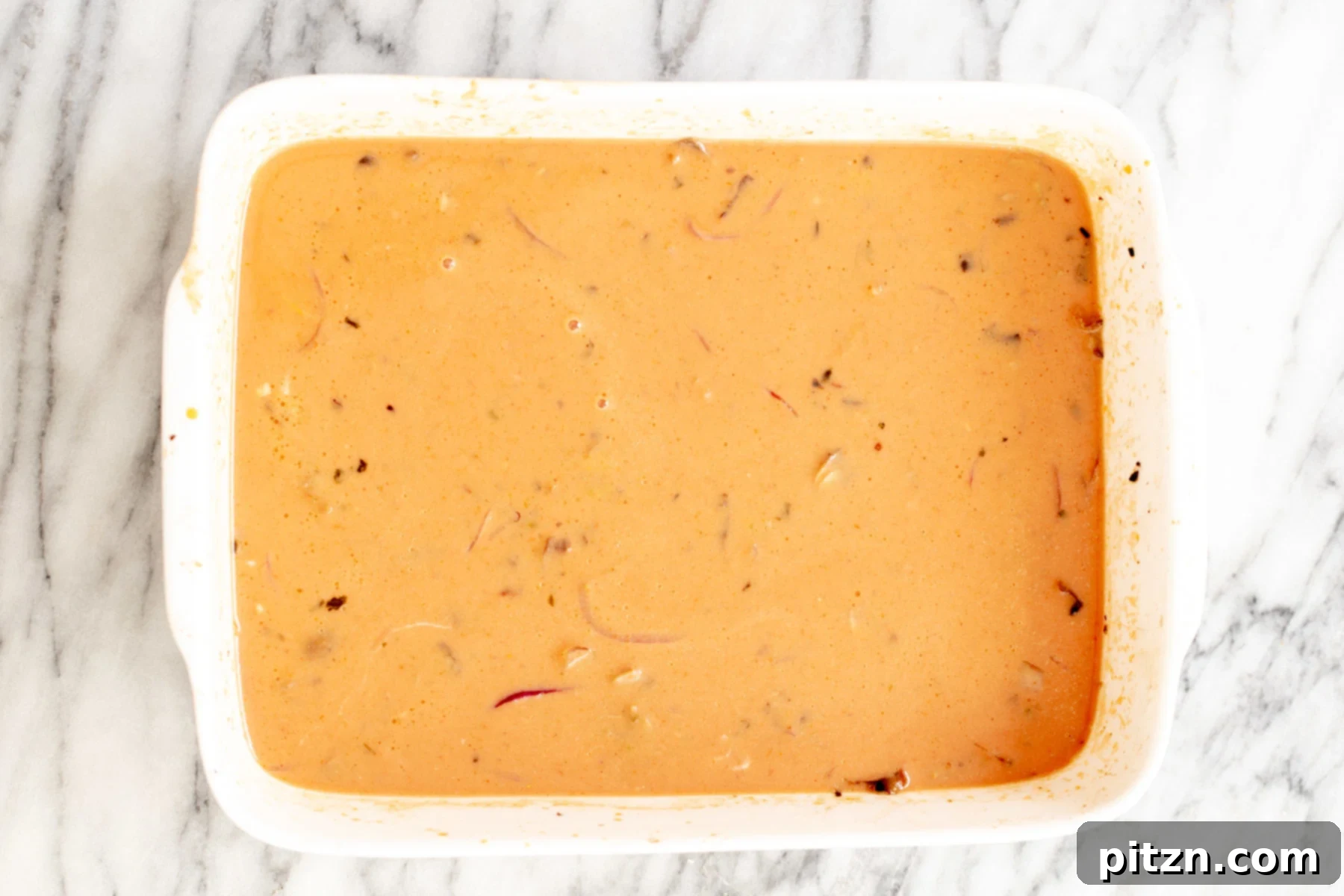 Another angle of the unbaked vegan butter chicken lasagna, highlighting the even distribution of pasta and sauce.