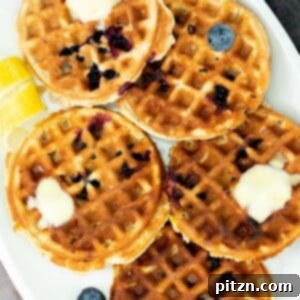 A plate of gluten-free lemon blueberry waffles, a perfect vegan breakfast or brunch.