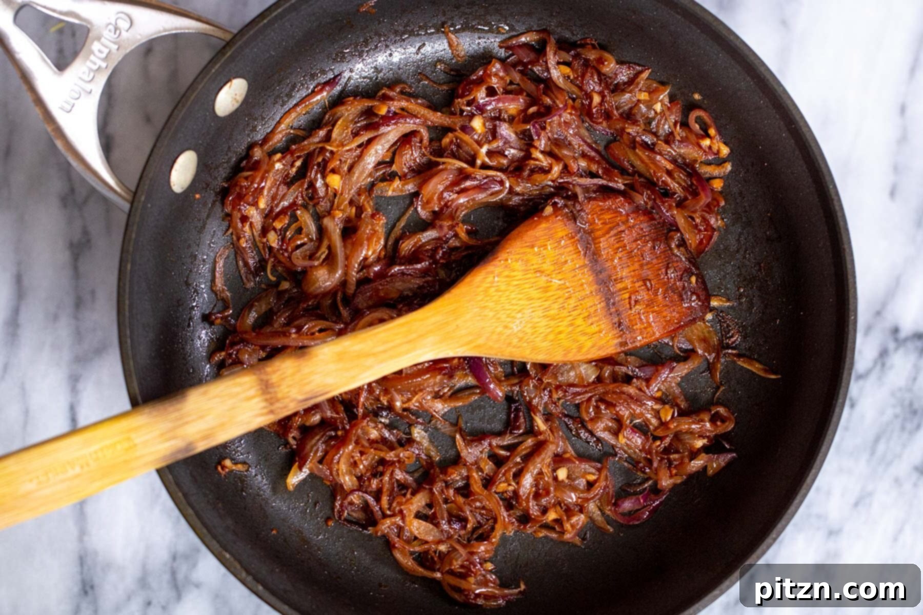 red onions, garlic and ginger in a black sauteeing pan 
