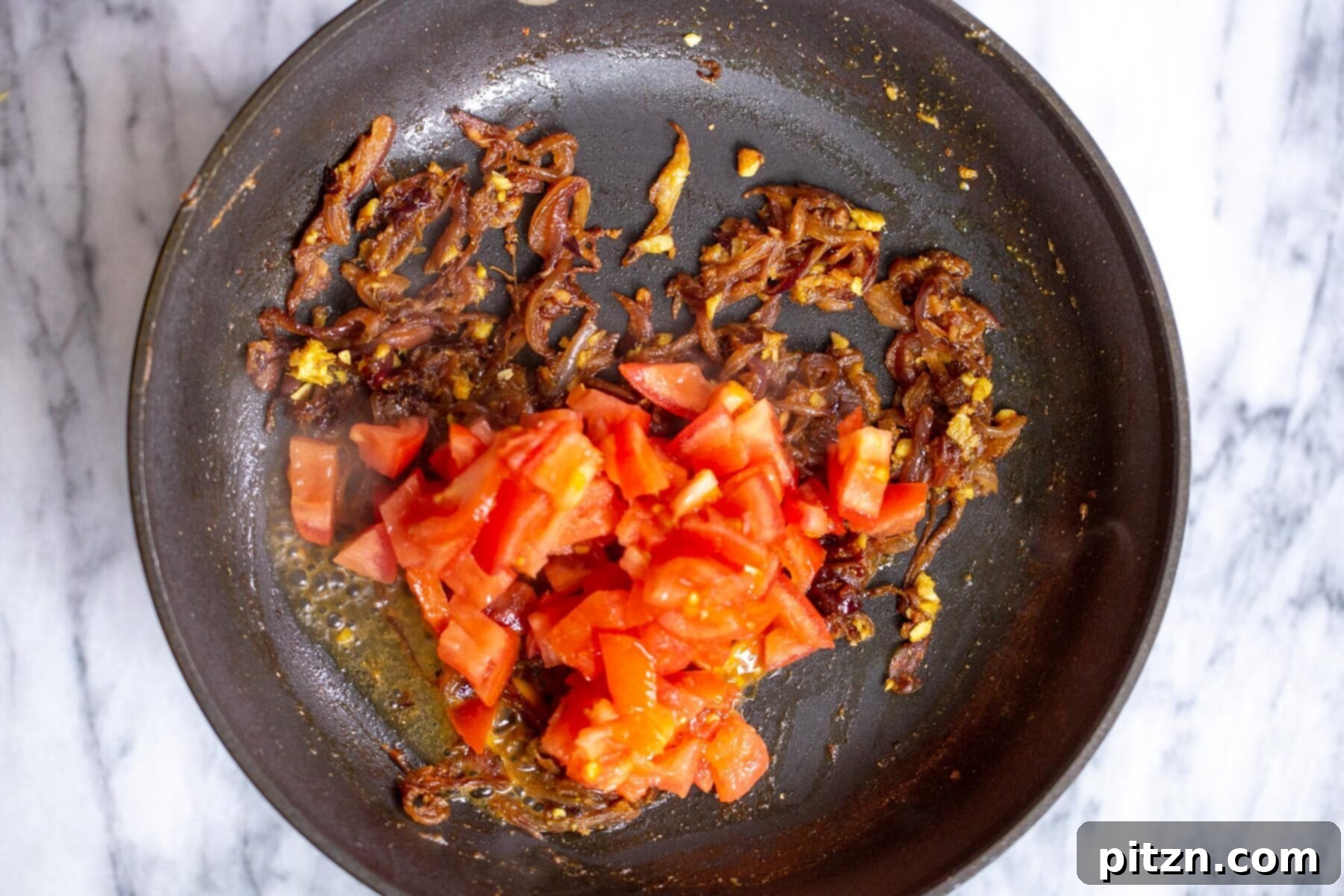fresh tomatoes being added to sauteeing pan 