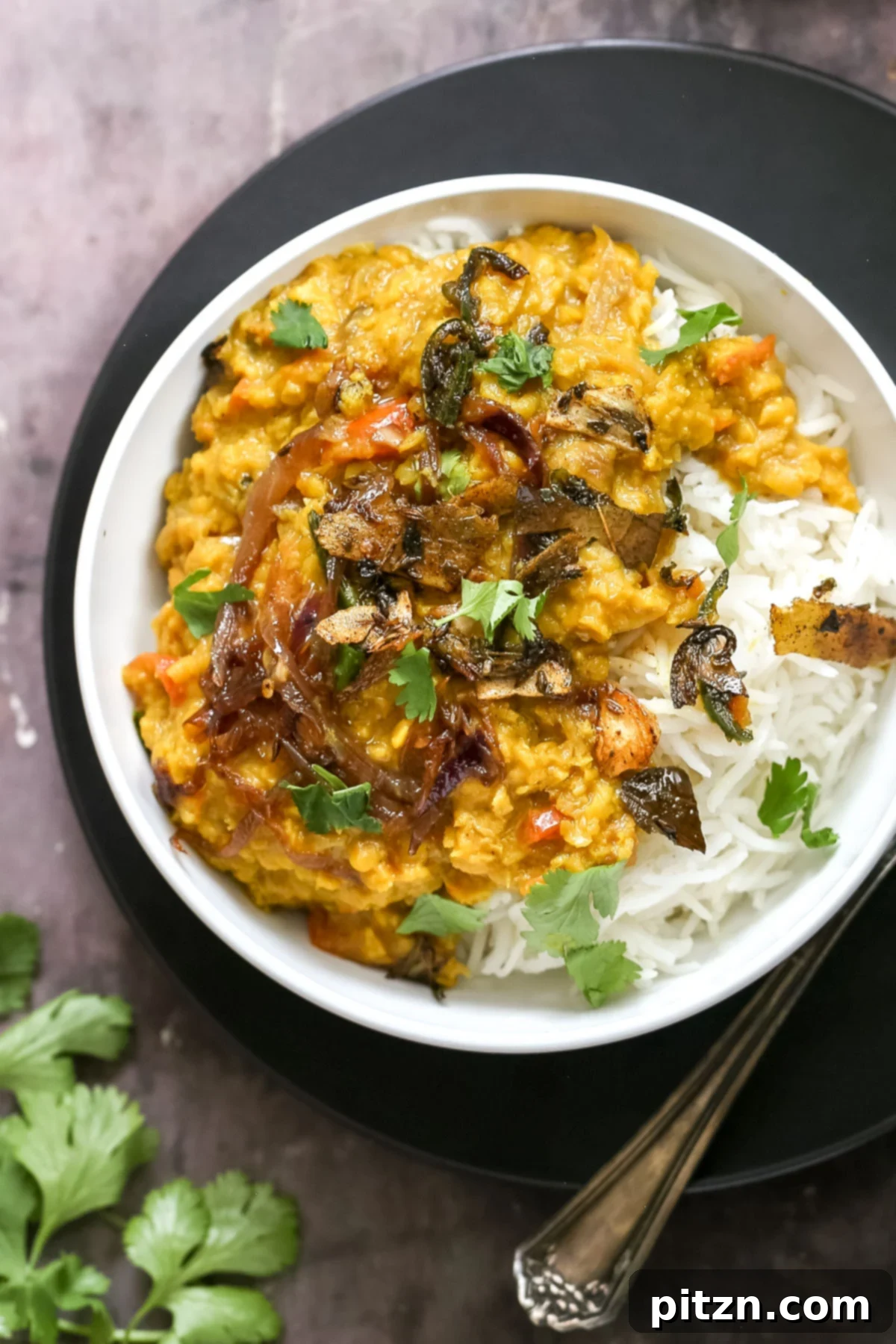red lentil daal served over rice sprinkled with cilantro 
