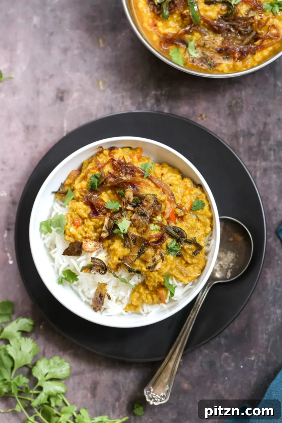 masoor dal tadka served over rice sprinkled with cilantro 