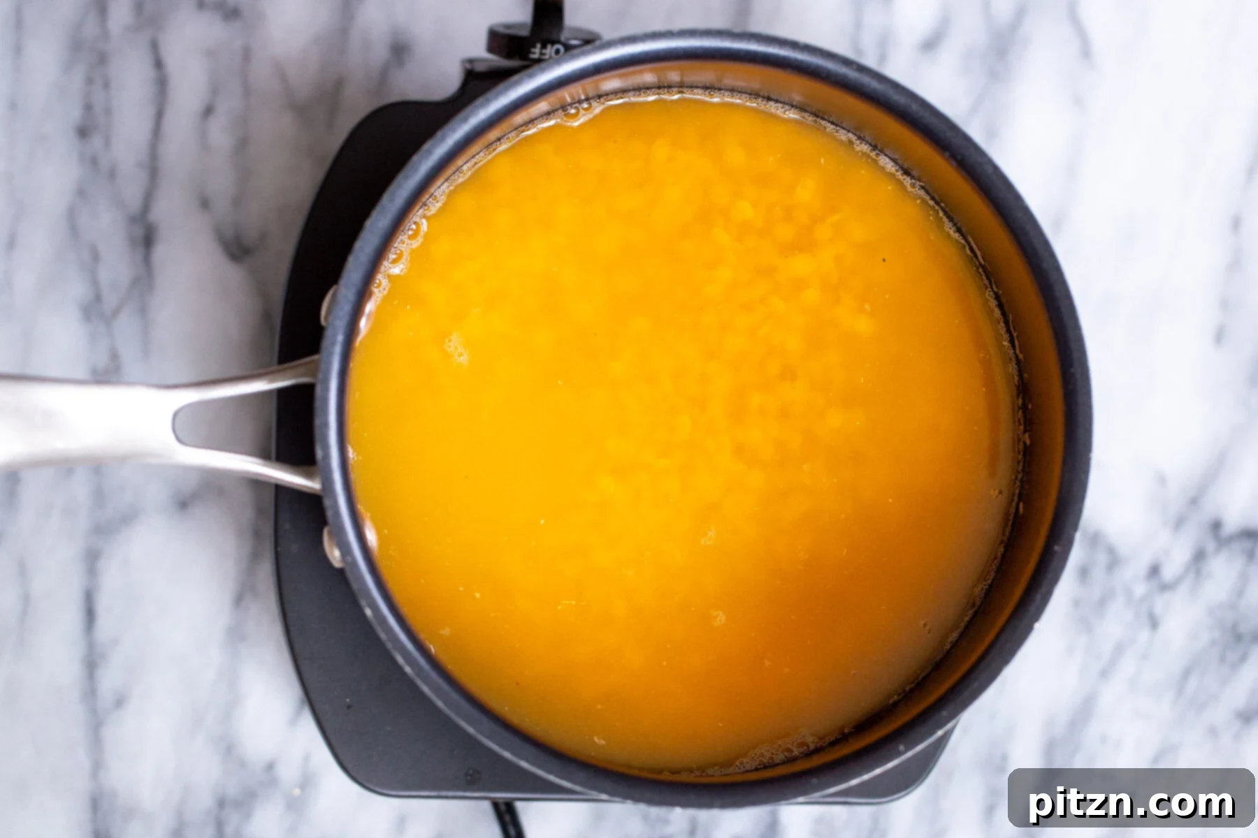 red lentils being cooked in a pot for making masoor dal tadka