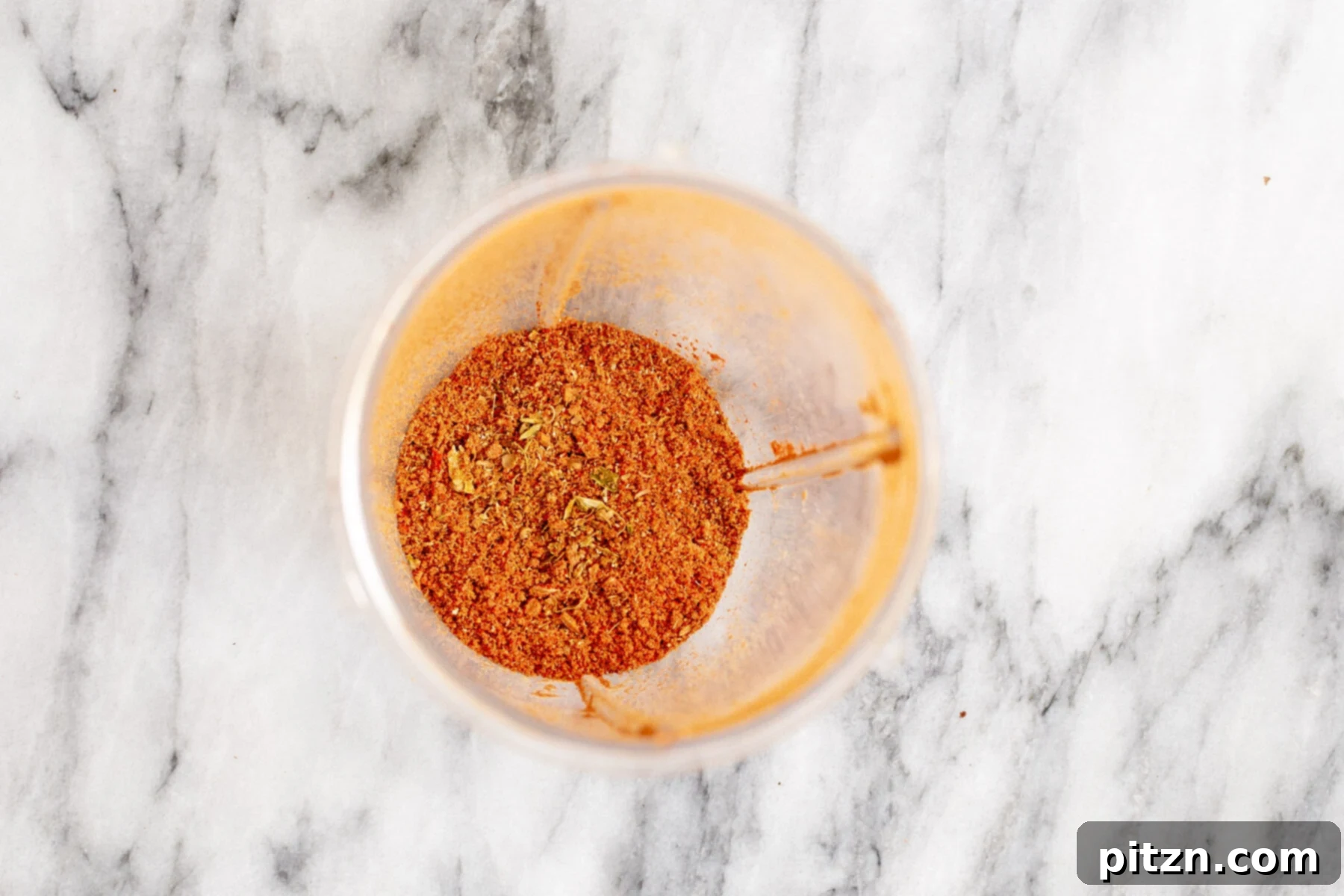 Vegan Tofu Rogan Josh 12 Finely ground Indian spices forming a vibrant blend on a marble countertop, ready for the curry base.