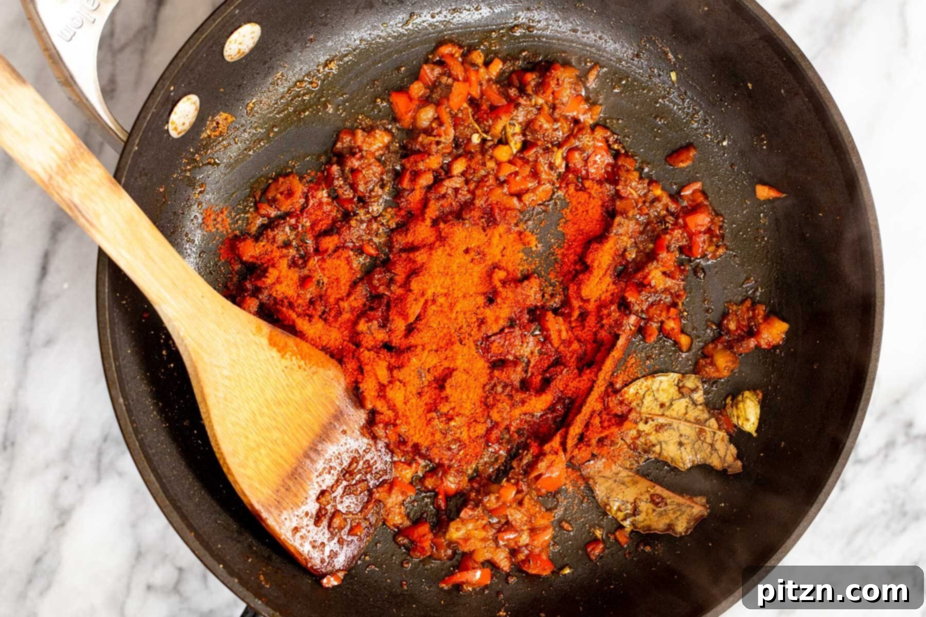 Vegan Tofu Rogan Josh 17 The ground spice mixture being added to the softened bell pepper and whole spices in a sauté pan.