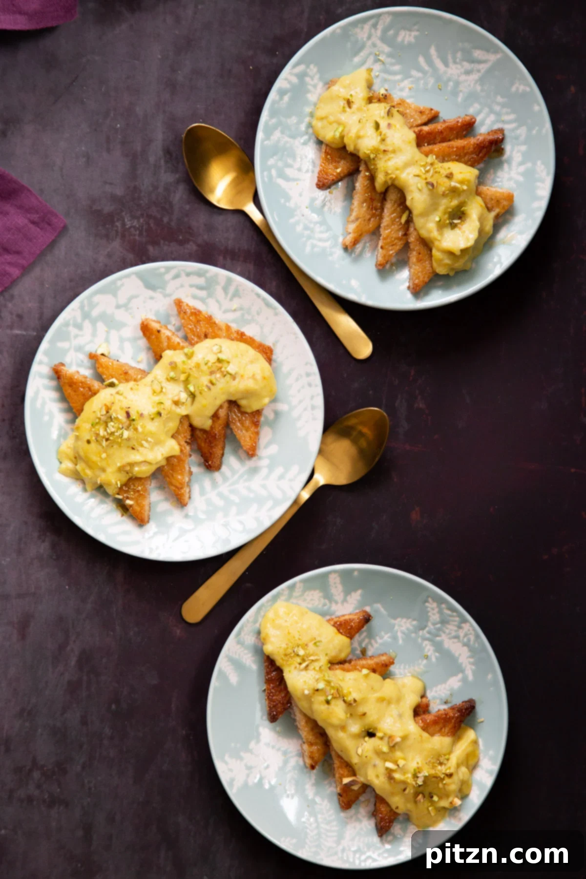 Shahi Tukda Royal Golden Toasts with Rabri Custard 3 Three individual servings of Vegan Shahi Tukda, showcasing the golden-baked bread beneath the creamy saffron Rabri.