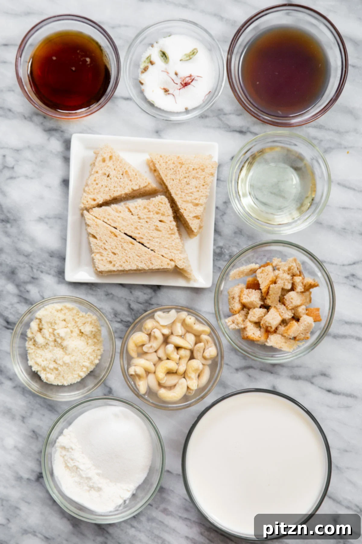 Shahi Tukda Royal Golden Toasts with Rabri Custard 6 Ingredients for Vegan Shahi Tukda laid out on a marble countertop, including bread, cashews, saffron, and cardamom.
