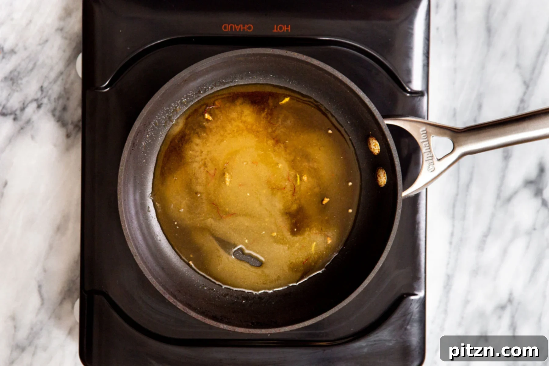 Shahi Tukda Royal Golden Toasts with Rabri Custard 9 The finished sugar syrup in a saucepan on a hot plate, ready for use.