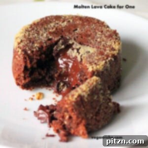 A molten lava cake on a white plate. A piece is broken away to show the melted chocolate centre