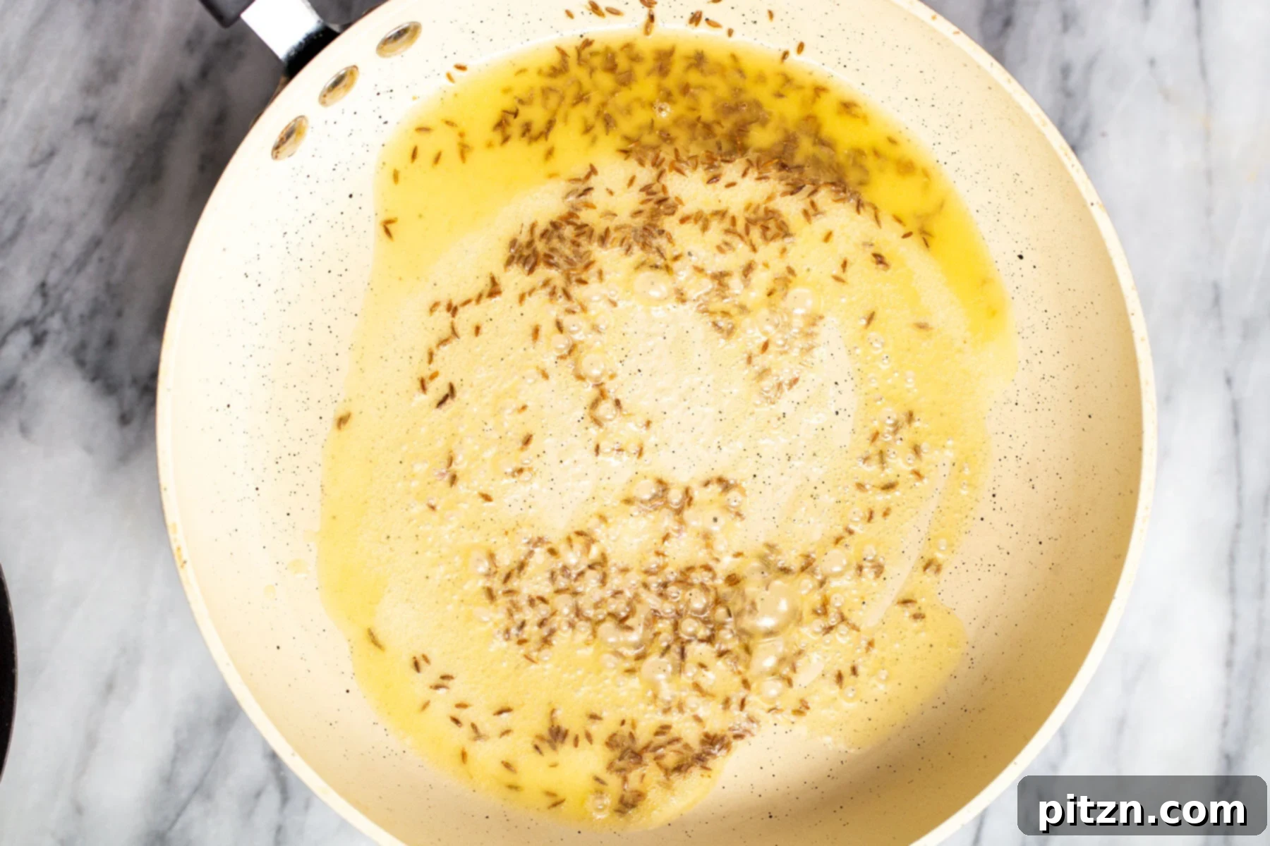 Creamy Plant-Based Dhaba Dal 11 Whole spices, including cumin, bay leaves, and dried chilies, frying in a pan