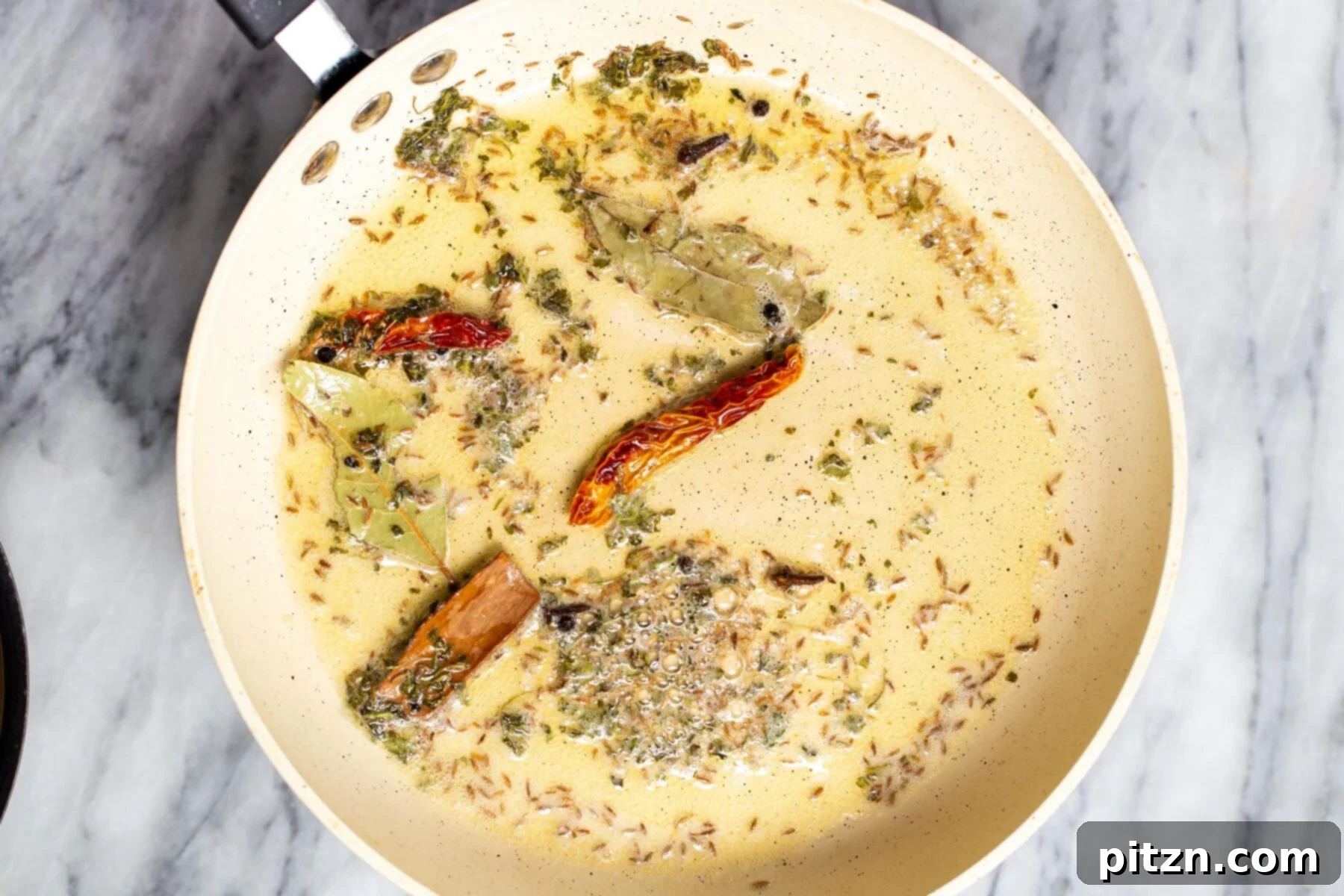 Creamy Plant-Based Dhaba Dal 12 Indian tadka mixture being prepared in a white sautéing pan for a dal recipe