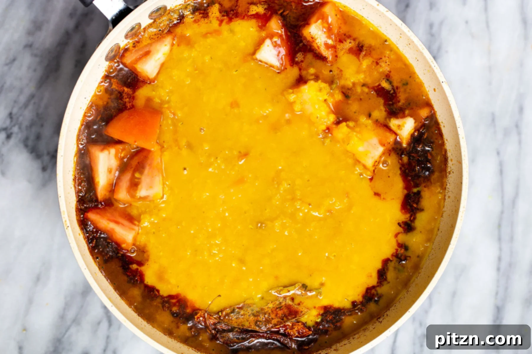 Creamy Plant-Based Dhaba Dal 15 Cooked dal being added to a pan with sizzling Indian tempering (tadka)