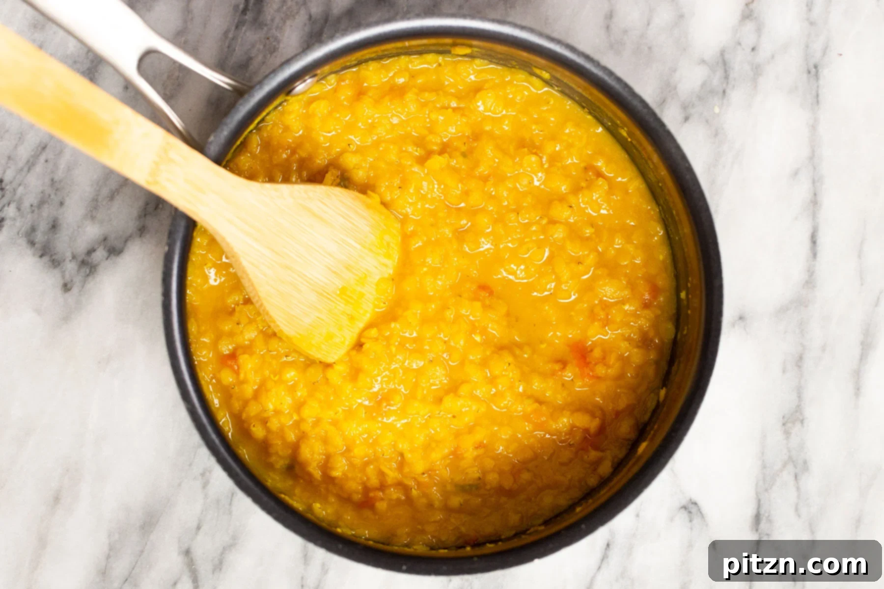 Creamy Plant-Based Dhaba Dal 9 Red lentils being cooked in a pot on the stovetop, simmering gently