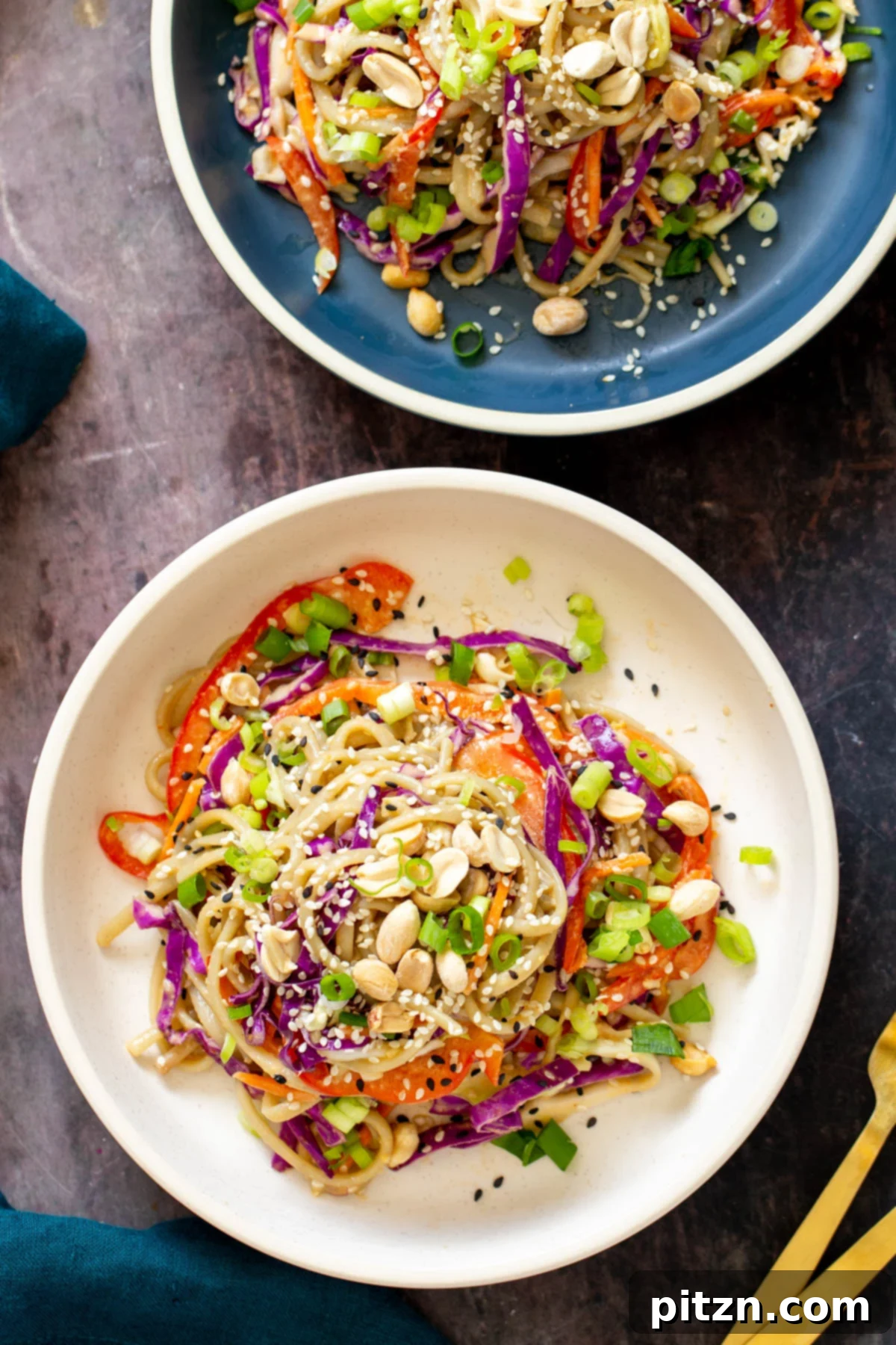 sesame noodle salad with creamy peanut butter dressing sprinkled with peanuts and sesame seeds, portioned for meal prep