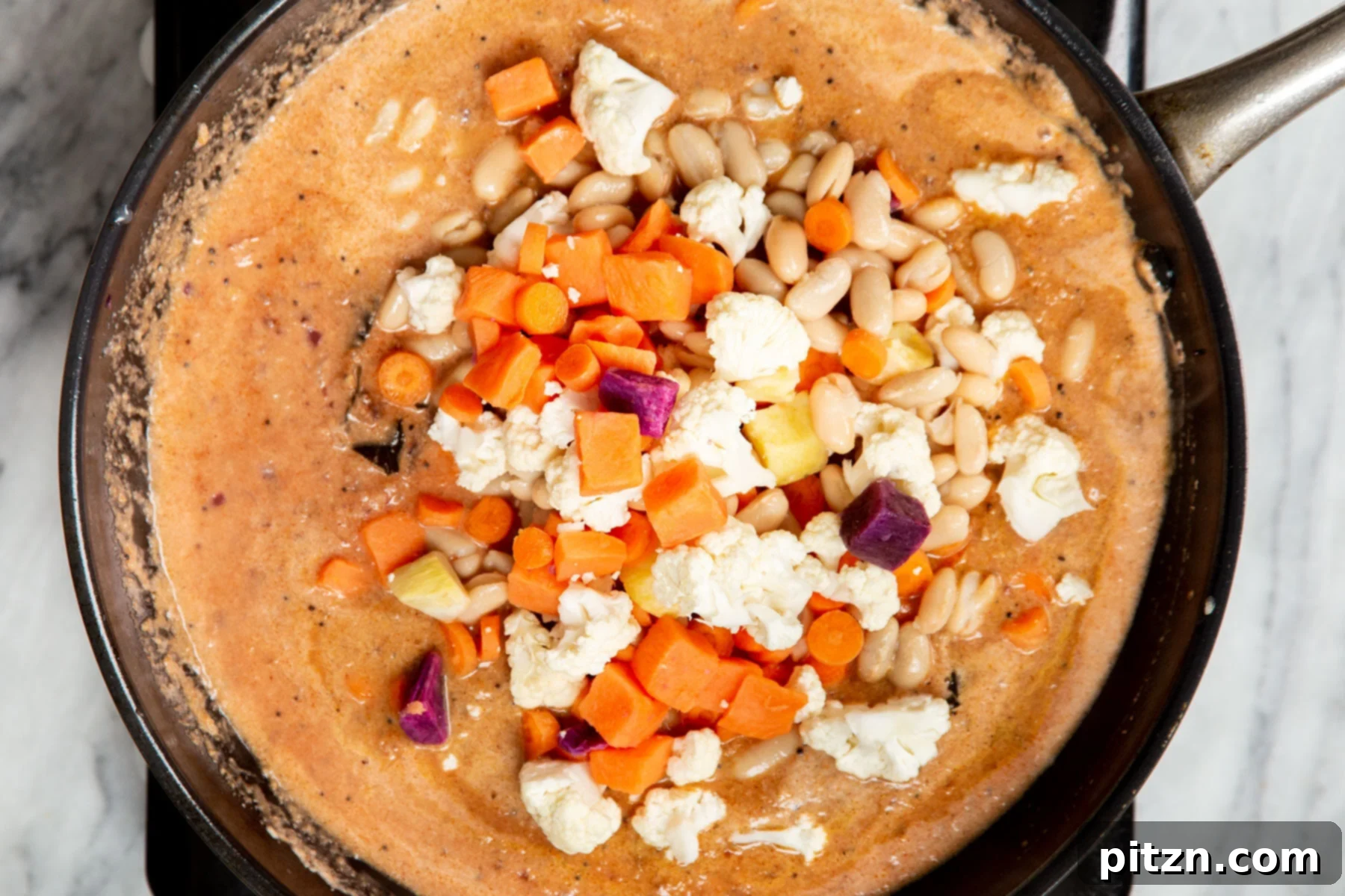Hearty Vegan Malabar Curry 16 Vegan Malabar curry sauce with a mix of vibrant vegetables in a skillet, bubbling gently.