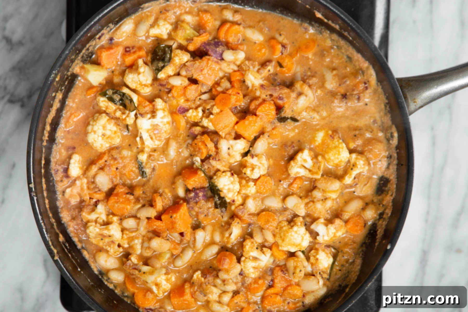 Hearty Vegan Malabar Curry 17 Close-up of vegan Malabar curry with a medley of colorful vegetables simmering beautifully in a skillet.