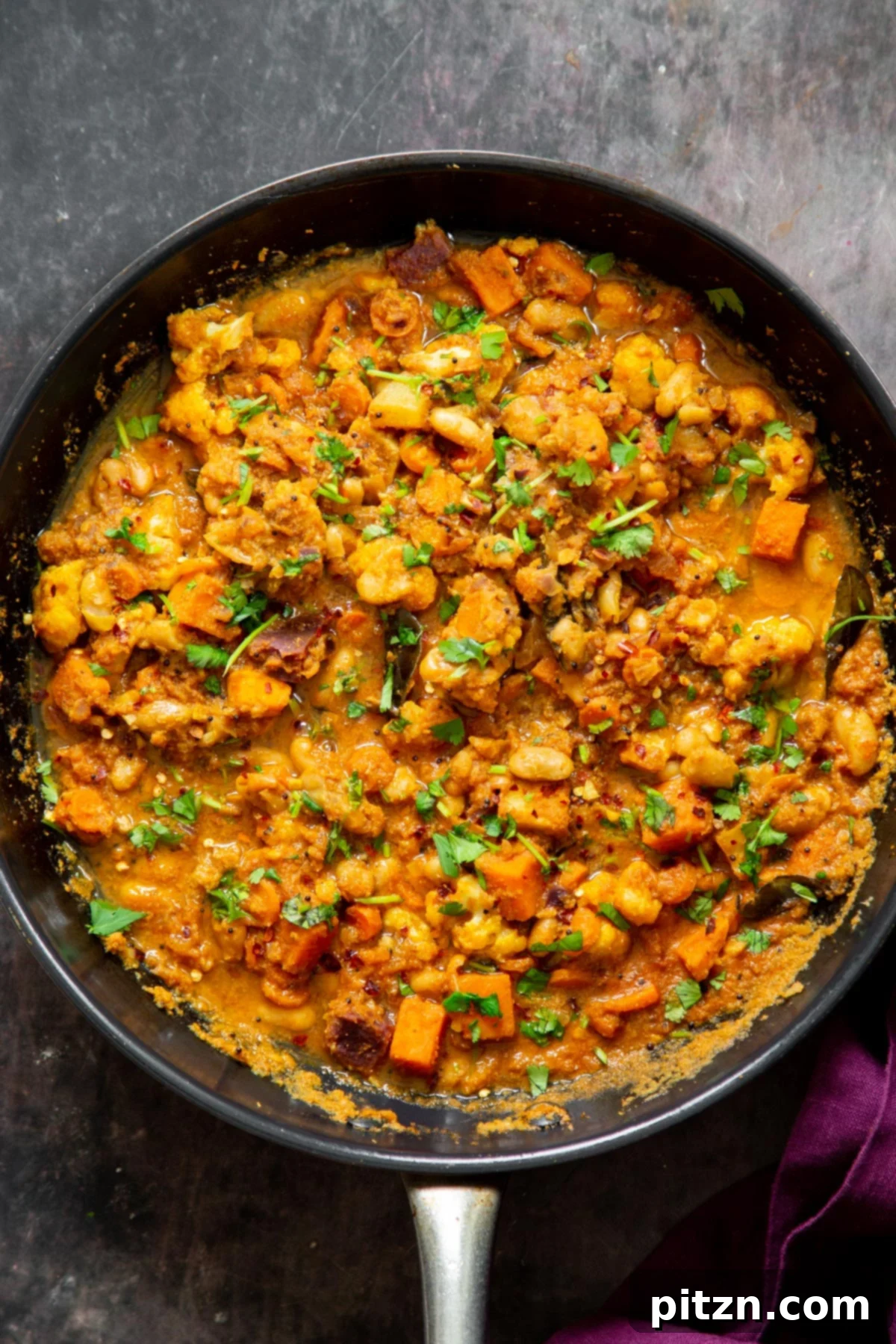 Hearty Vegan Malabar Curry 6 A black skillet showcasing the hearty and vibrant vegan Malabar curry, ready to be served.