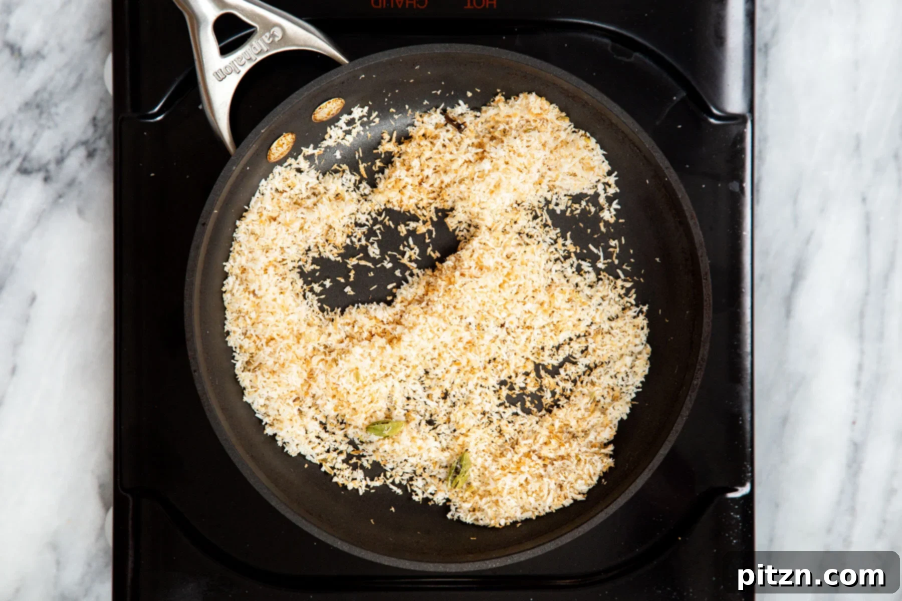 Hearty Vegan Malabar Curry 9 Toasted golden-brown coconut and whole spices resting in a sautéing pan.