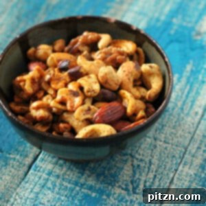 A bowl of spiced roasted nuts on a blue wood background, perfectly golden and ready to serve.