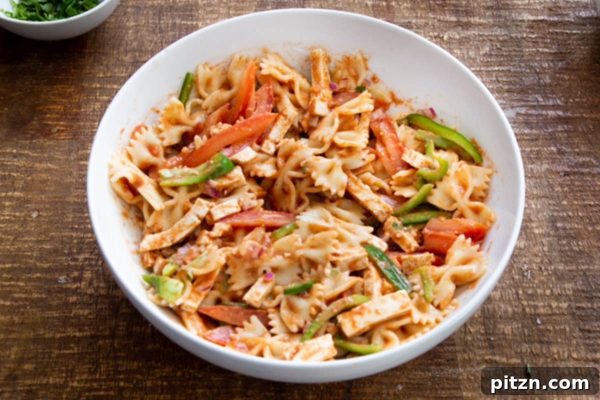 Fusion Tikka Pasta Salad 13 Tossed vegan Tikka Masala Pasta Salad in a white salad bowl