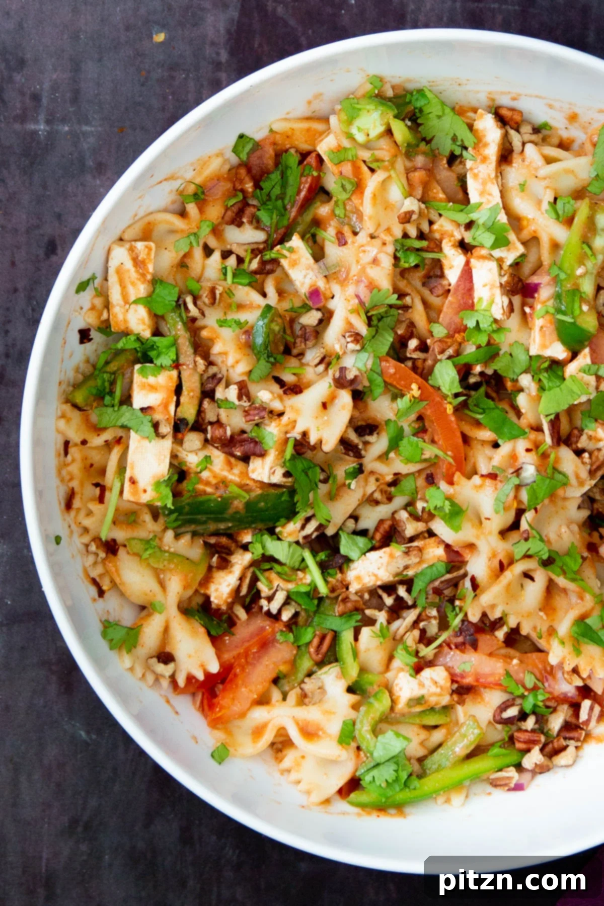 Fusion Tikka Pasta Salad 3 A vibrant bowl of vegan Tikka Masala Pasta Salad garnished with fresh herbs