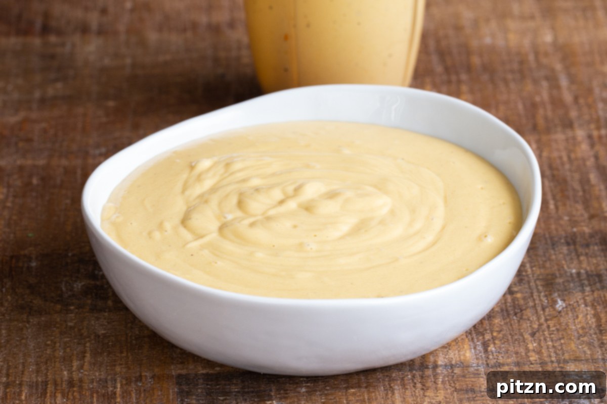 A small bowl filled with rich, creamy vegan cheese sauce.