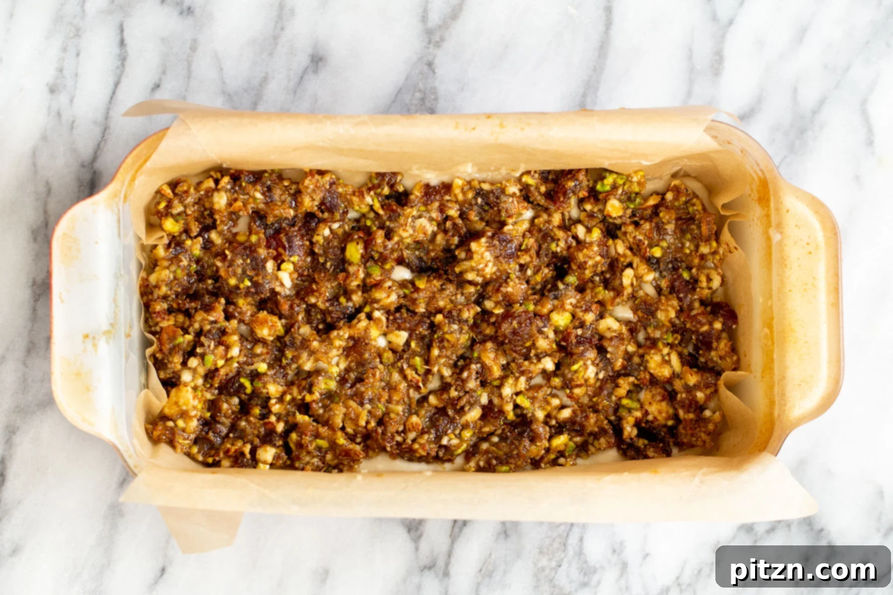 The aromatic nut and date mixture beautifully spread on top of the cake batter, creating a decadent layer.