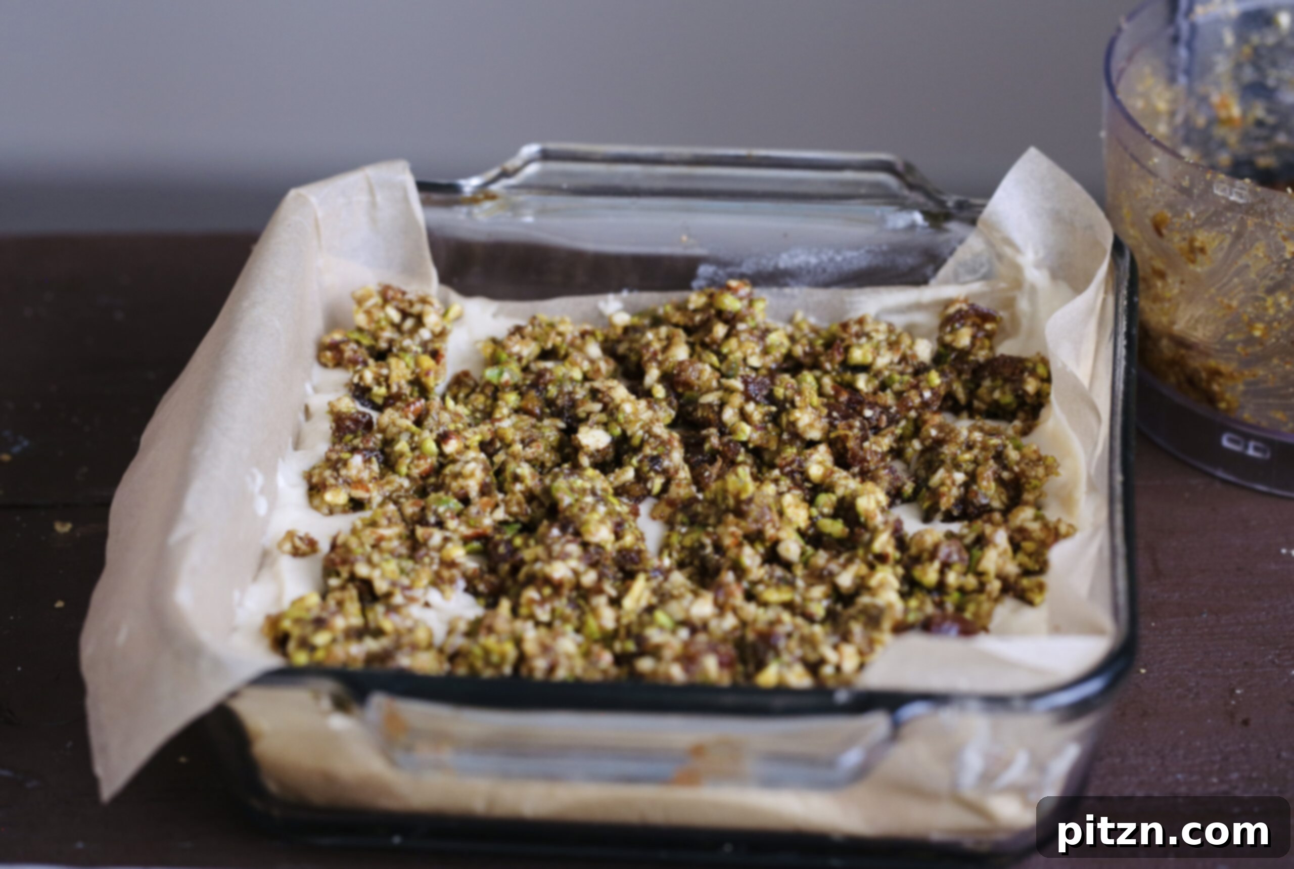 Vegan baklava cake batter layered in a square baking dish, prepared for the oven.
