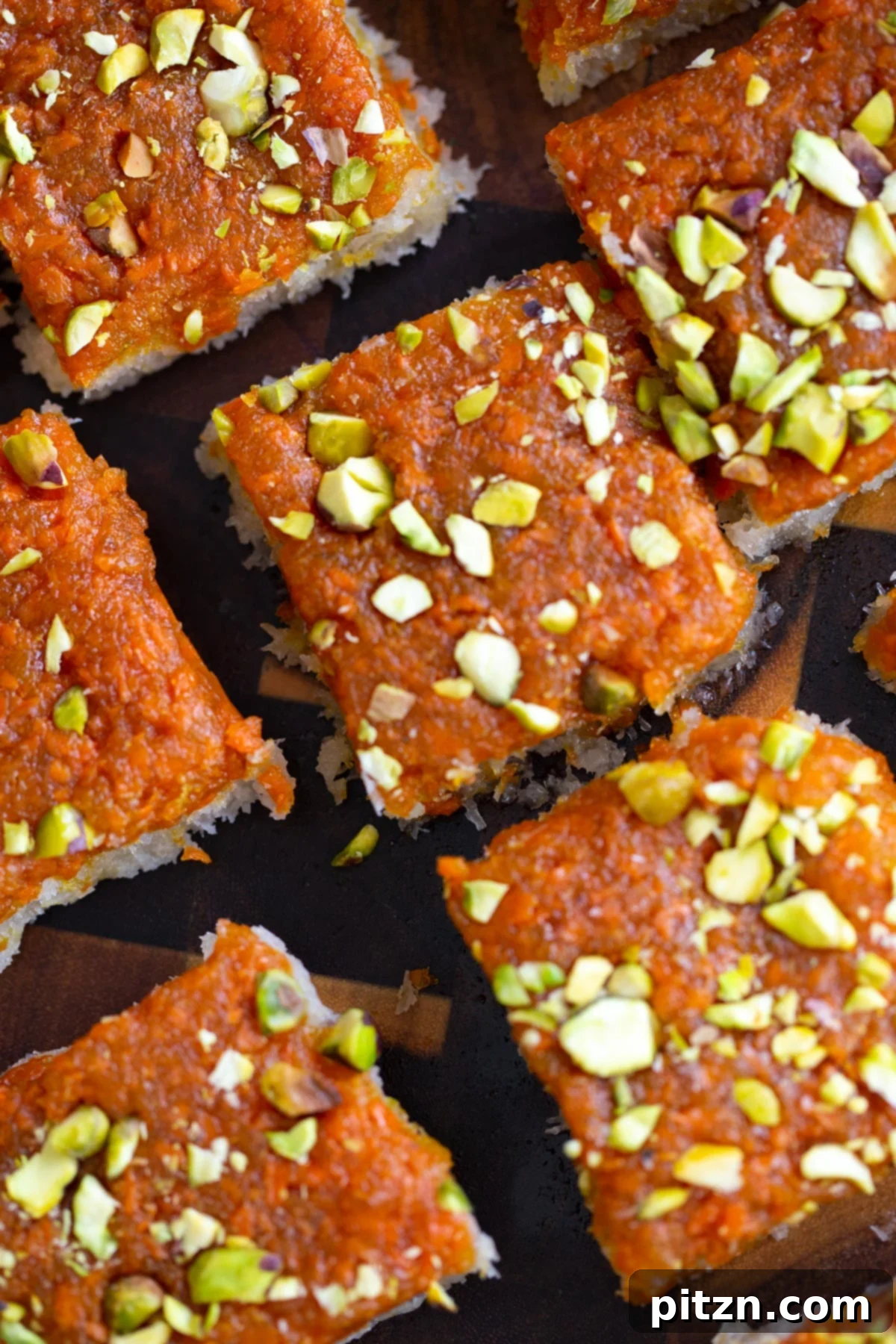Layered Vegan Carrot Halwa Coconut Burfi 2 carrot halwa coconut burfi bars topped with chopped pistachios