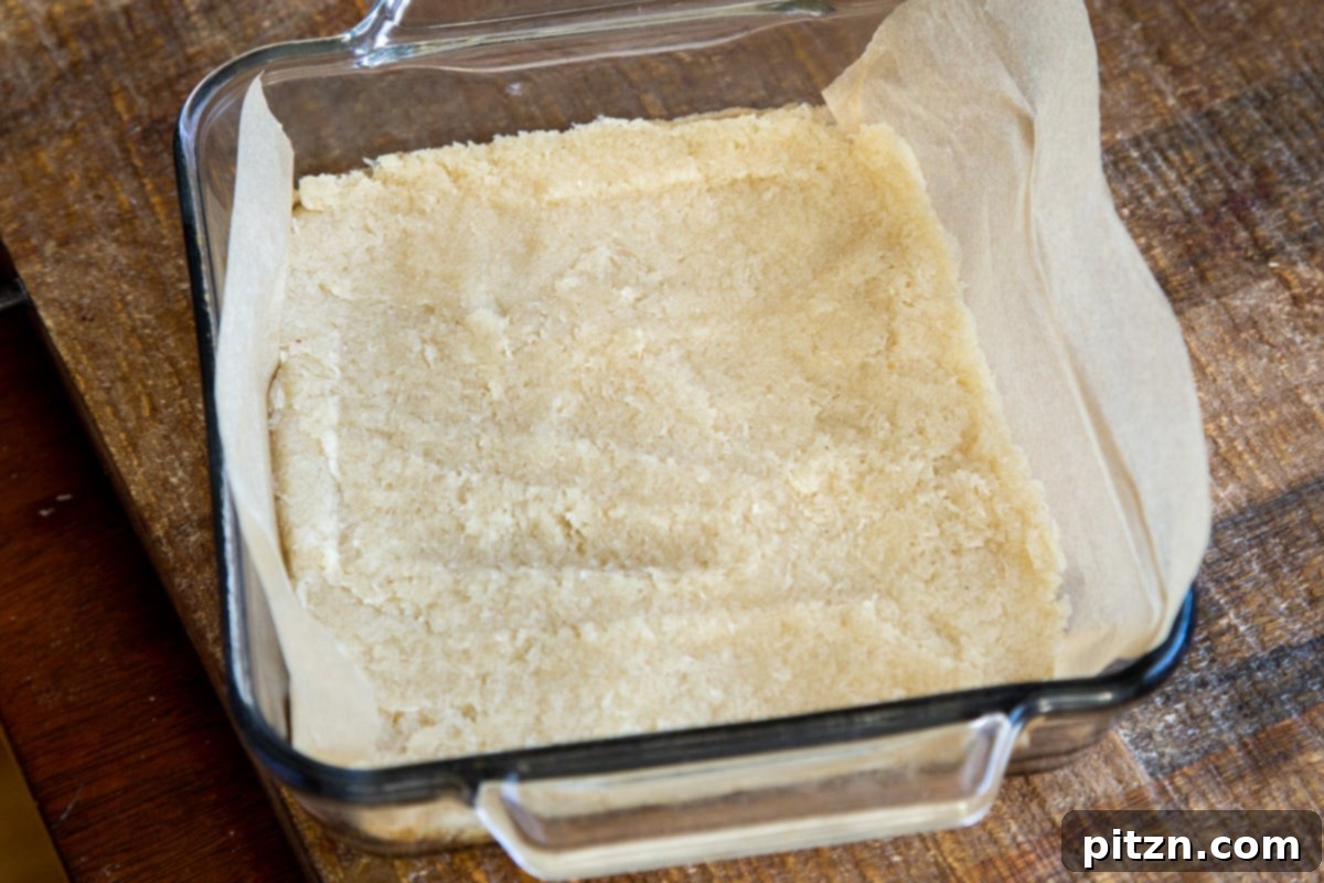 Layered Vegan Carrot Halwa Coconut Burfi 11 coconut burfi batter being pressed into a rectangular pan