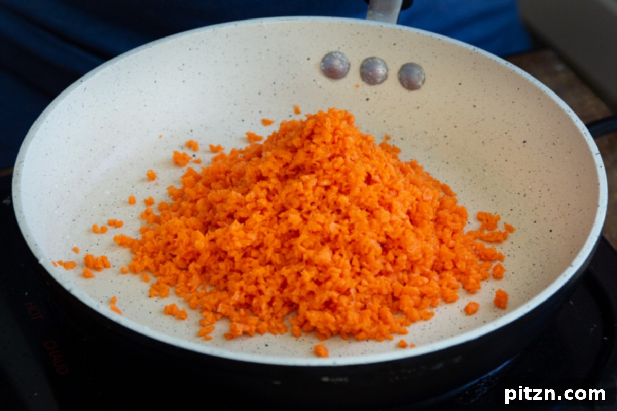 Layered Vegan Carrot Halwa Coconut Burfi 12 shredded carrots being added to sauteeing pan
