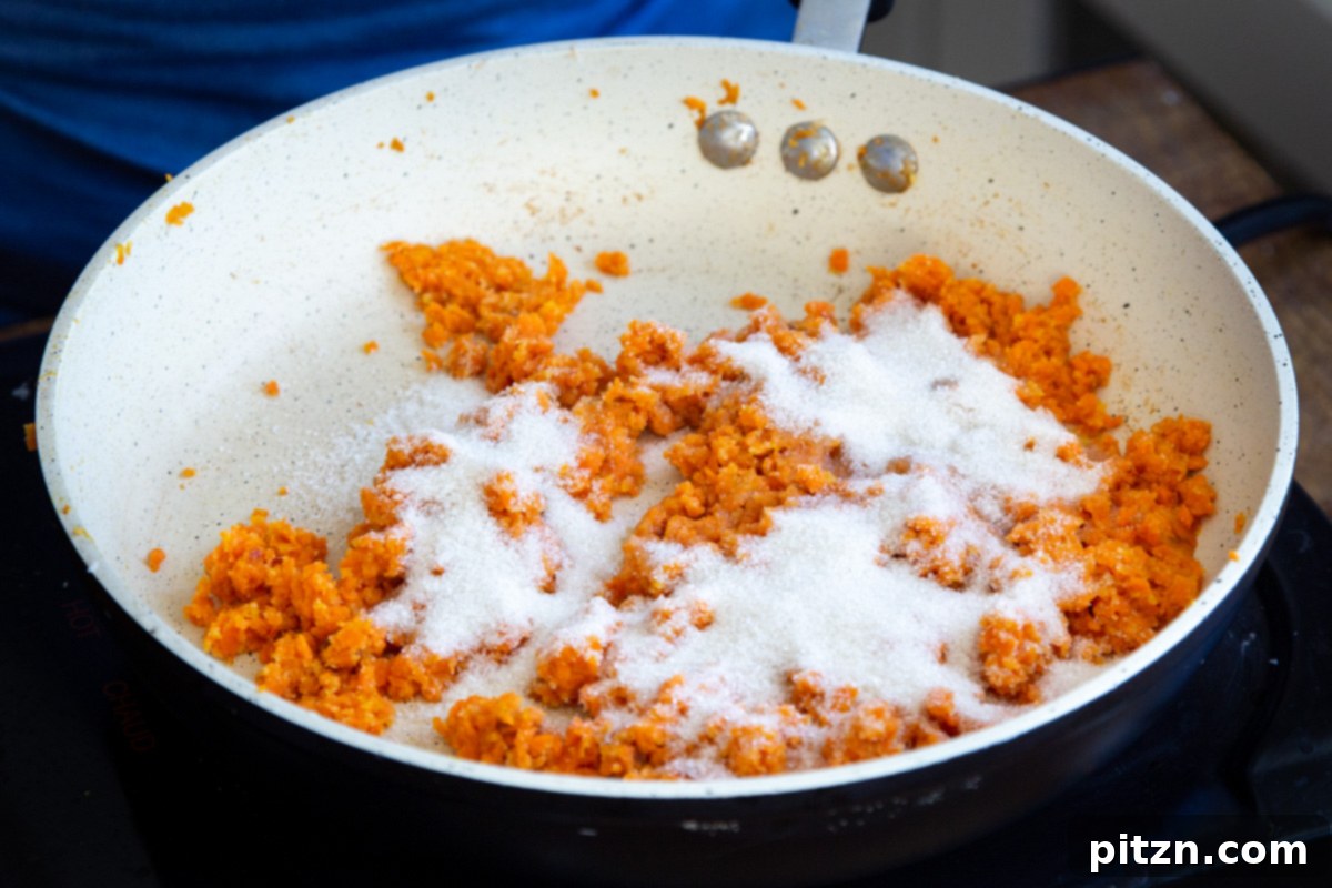Layered Vegan Carrot Halwa Coconut Burfi 15 sugar and shredded sauteed carrots in a sauteeing pan