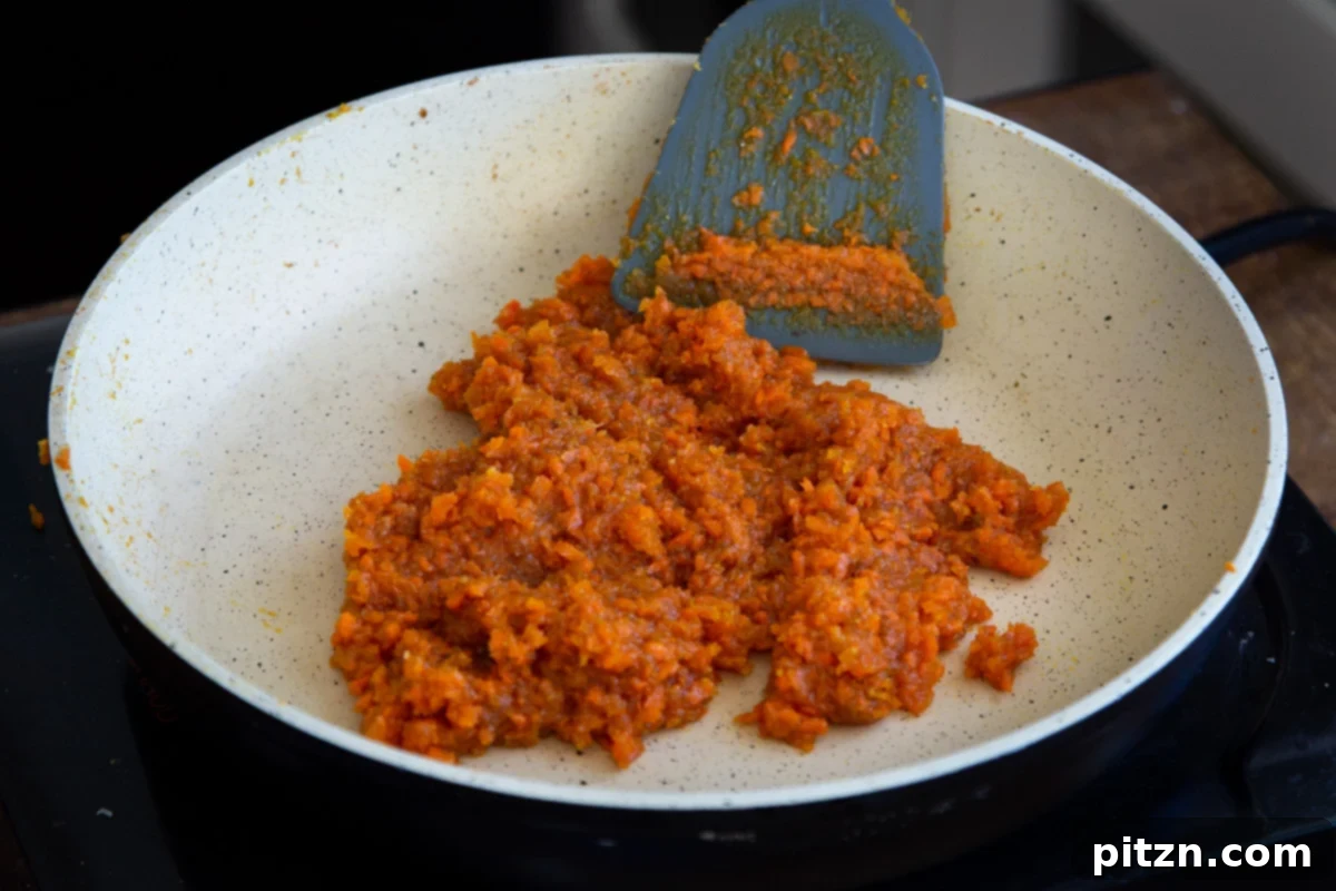Layered Vegan Carrot Halwa Coconut Burfi 17 shredded caramelized carrots in a frying pan