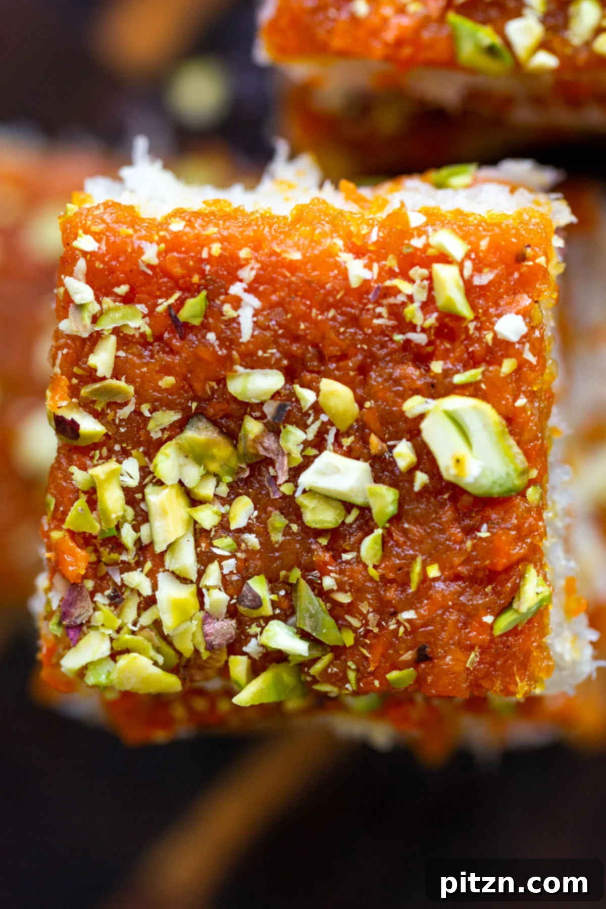 Layered Vegan Carrot Halwa Coconut Burfi 4 carrot halwa coconut burfi bars topped with chopped pistachios