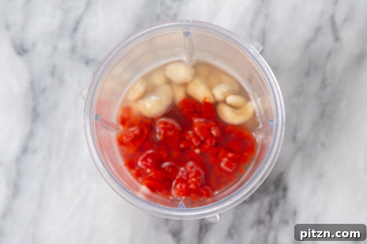 Flavorful Lasooni Vegan Chicken Curry, Entirely Tomato-Free 10 Raw cashews and roasted red bell peppers placed inside a blender, ready to be pureed for the curry sauce.