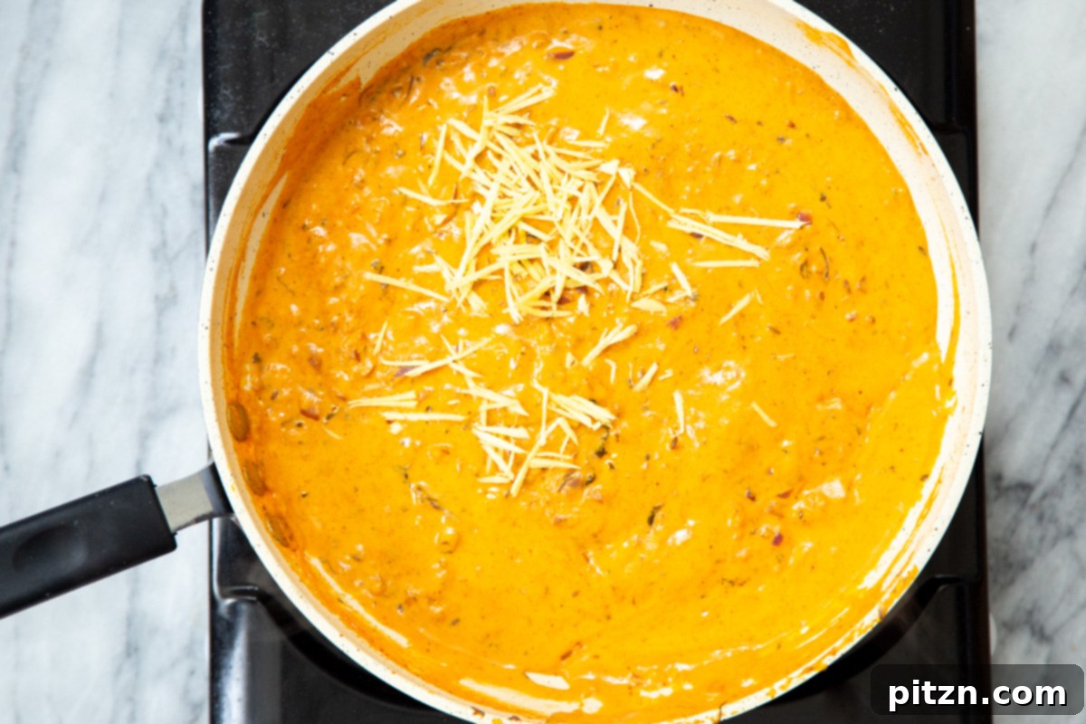 Flavorful Lasooni Vegan Chicken Curry, Entirely Tomato-Free 13 Creamy red bell pepper gravy simmering in a sauté pan, absorbing all the aromatic spices.
