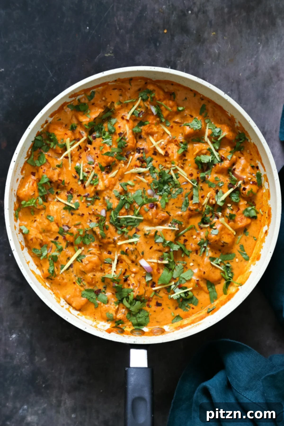 Flavorful Lasooni Vegan Chicken Curry, Entirely Tomato-Free 3 A pan filled with vibrant Indian Lasooni Chicken curry made with tofu, garnished with fresh cilantro.
