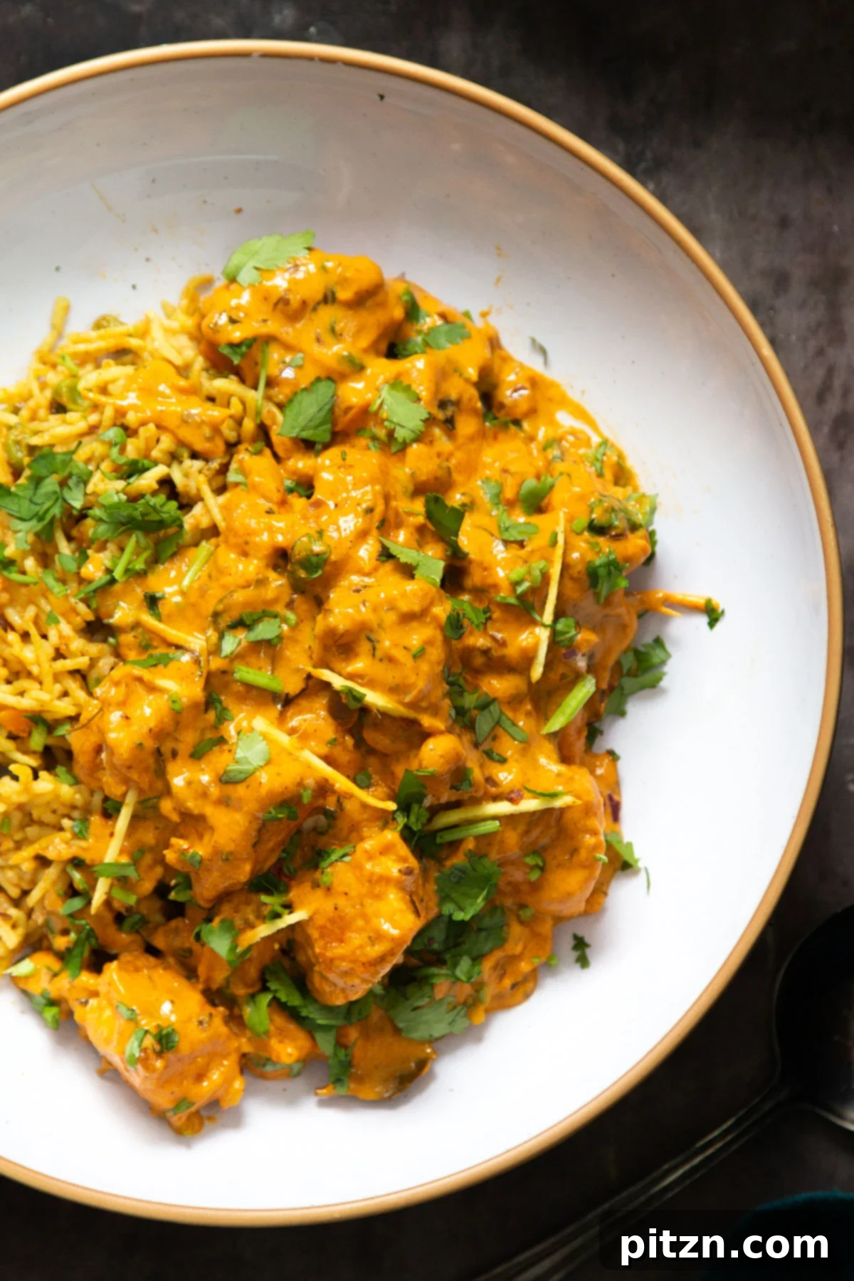 Flavorful Lasooni Vegan Chicken Curry, Entirely Tomato-Free 5 A serving of creamy vegan Lasooni Tofu curry on a white plate, garnished with fresh ginger and cilantro.