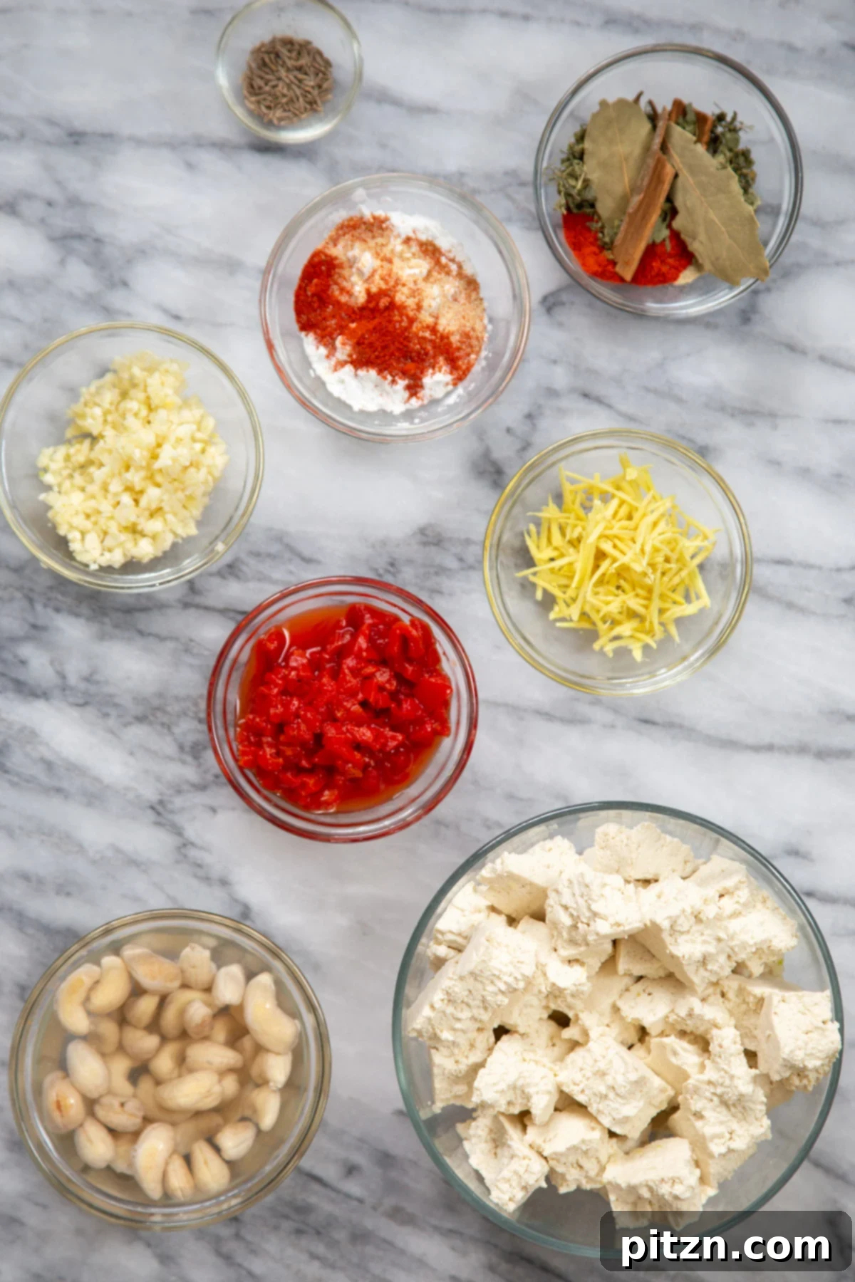 Flavorful Lasooni Vegan Chicken Curry, Entirely Tomato-Free 6 A collection of fresh ingredients for making Indian Lasooni Tofu Curry laid out on a marble counter.