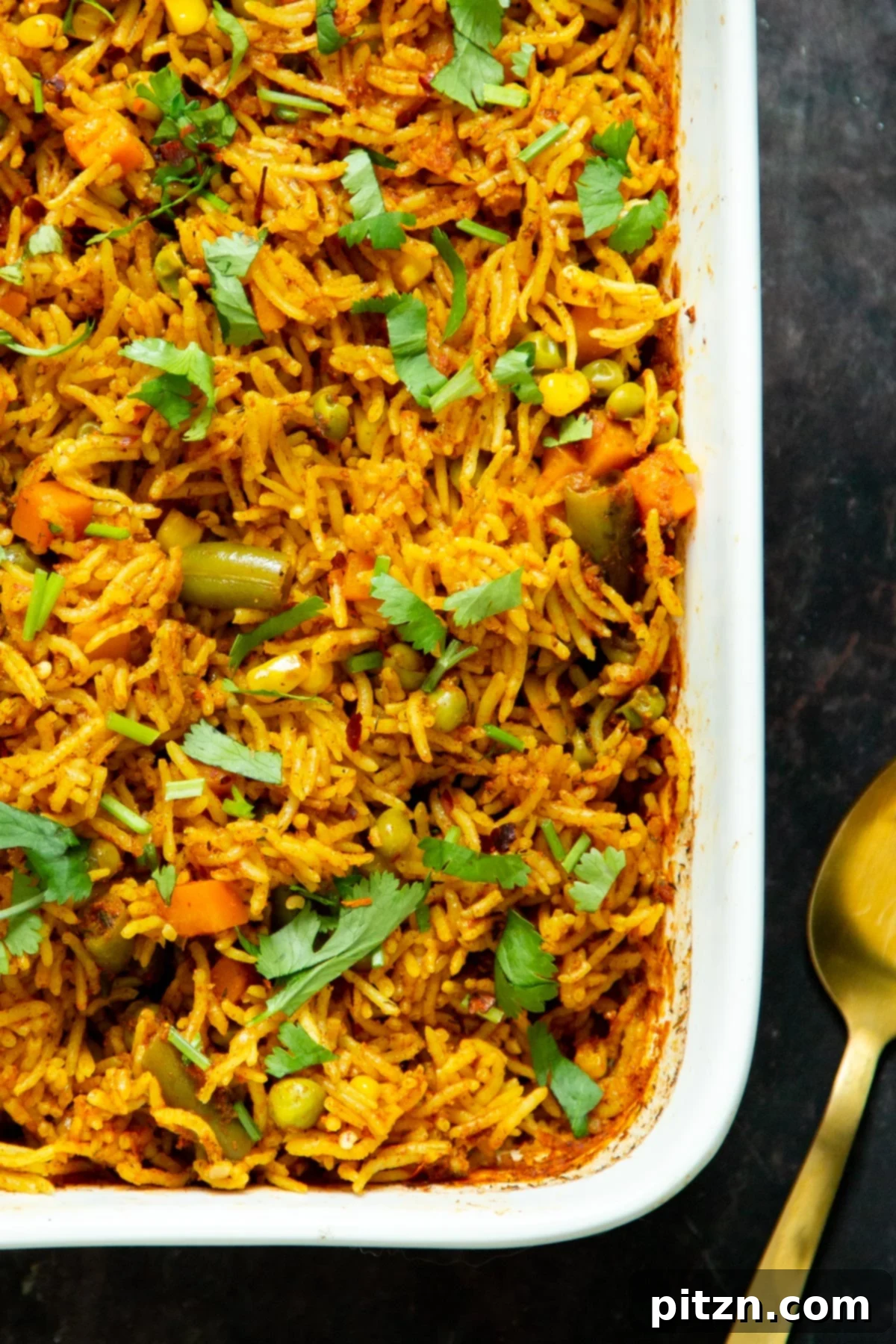 A beautifully baked white casserole dish of rice, freshly sprinkled with vibrant chopped cilantro.