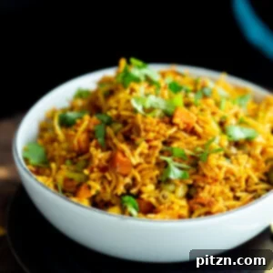 A small bowl of vegan masala rice casserole sprinkled with chopped cilantro, ready to be served.