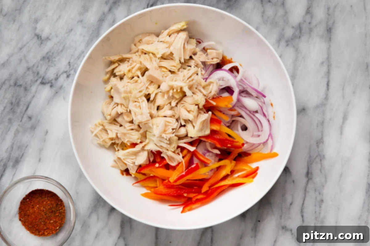 Quick & Easy Vegan Jackfruit Tacos 10 shredded jackfruit, bell pepper and onion in white bowl