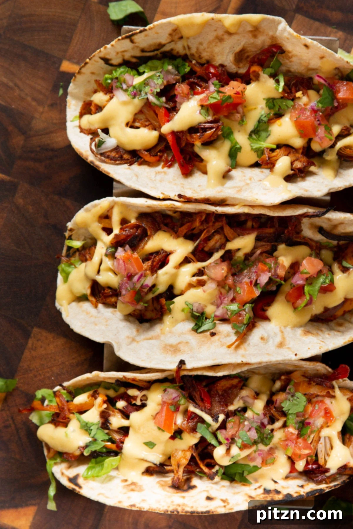 Quick & Easy Vegan Jackfruit Tacos 4 three jackfruit tacos topped with vegetables and cheese sauce
