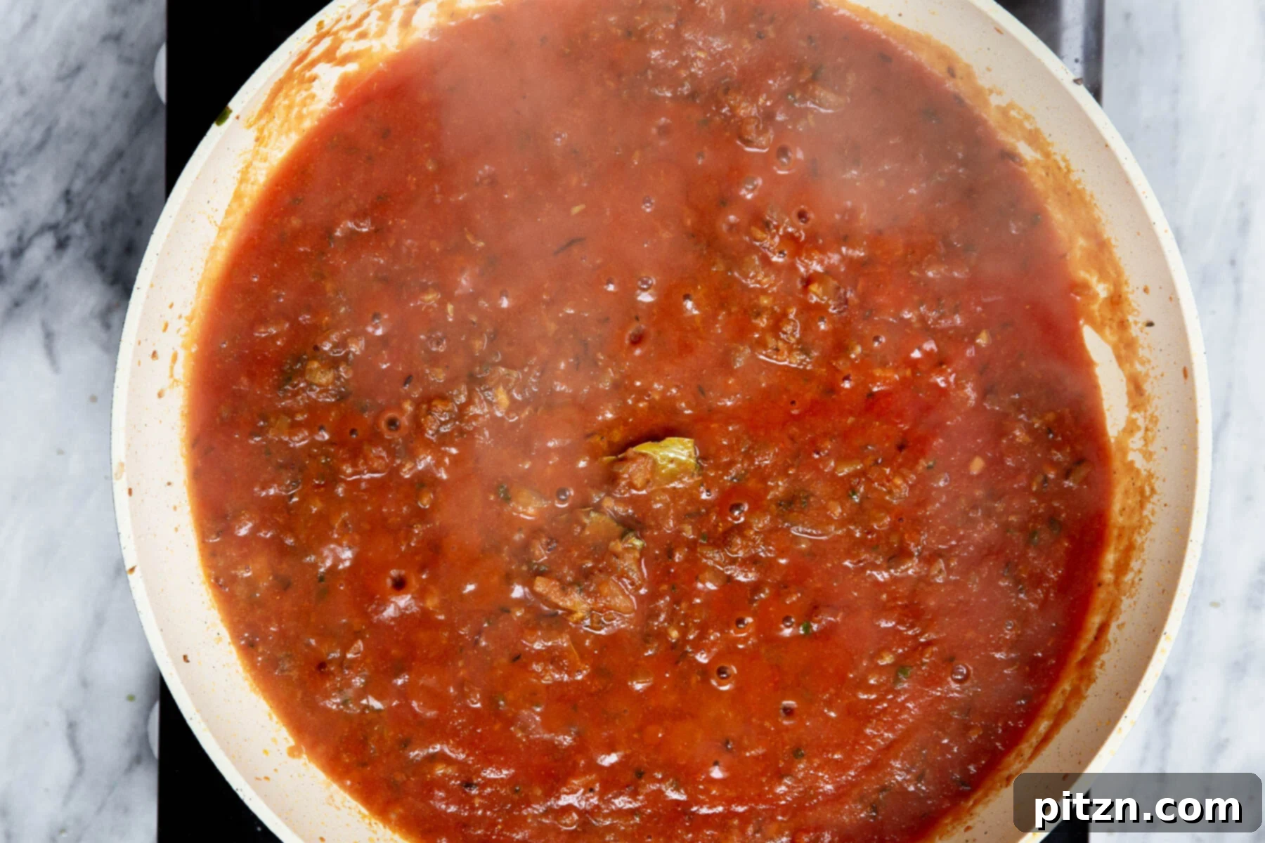 Vegan Tofu Matar 20 spiced tomato sauce simmering in a pan